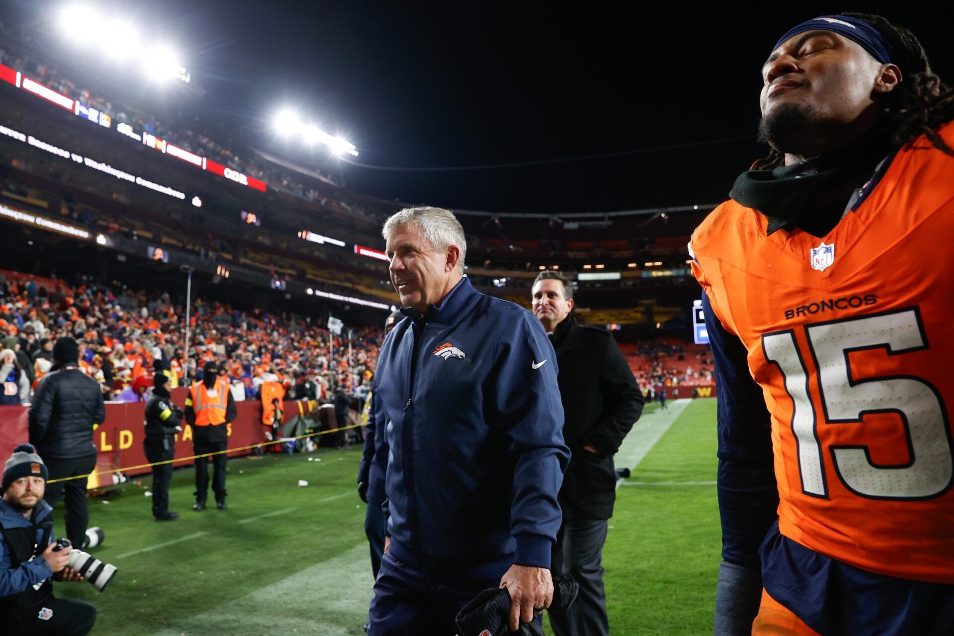 Denver Broncos head coach Sean Payton walks off the field with linebacker Nik Bonitto (15) after the game against the Washington Commanders at Northwest Stadium.