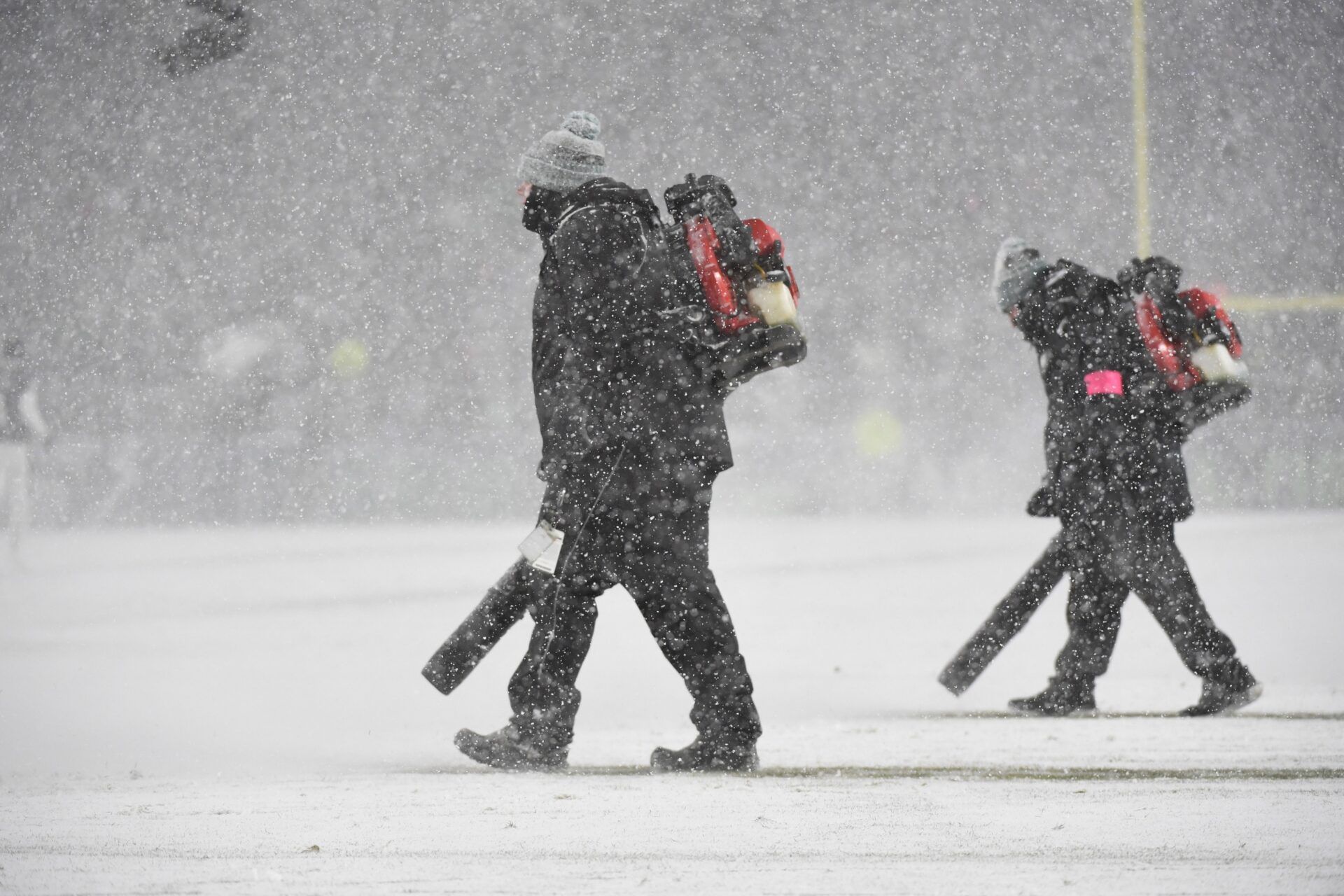 Crew members create lines on the field after snow falls during the 2025 NFC divisional round game between the Los Angeles Rams and the Philadelphia Eagles at Lincoln Financial Field.