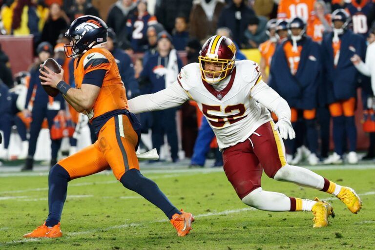 Denver Broncos quarterback Bo Nix (10) scrambles with the ball under pressure from Washington Commanders linebacker Preston Smith (52) in the fourth quarter of the game at Northwest Stadium.