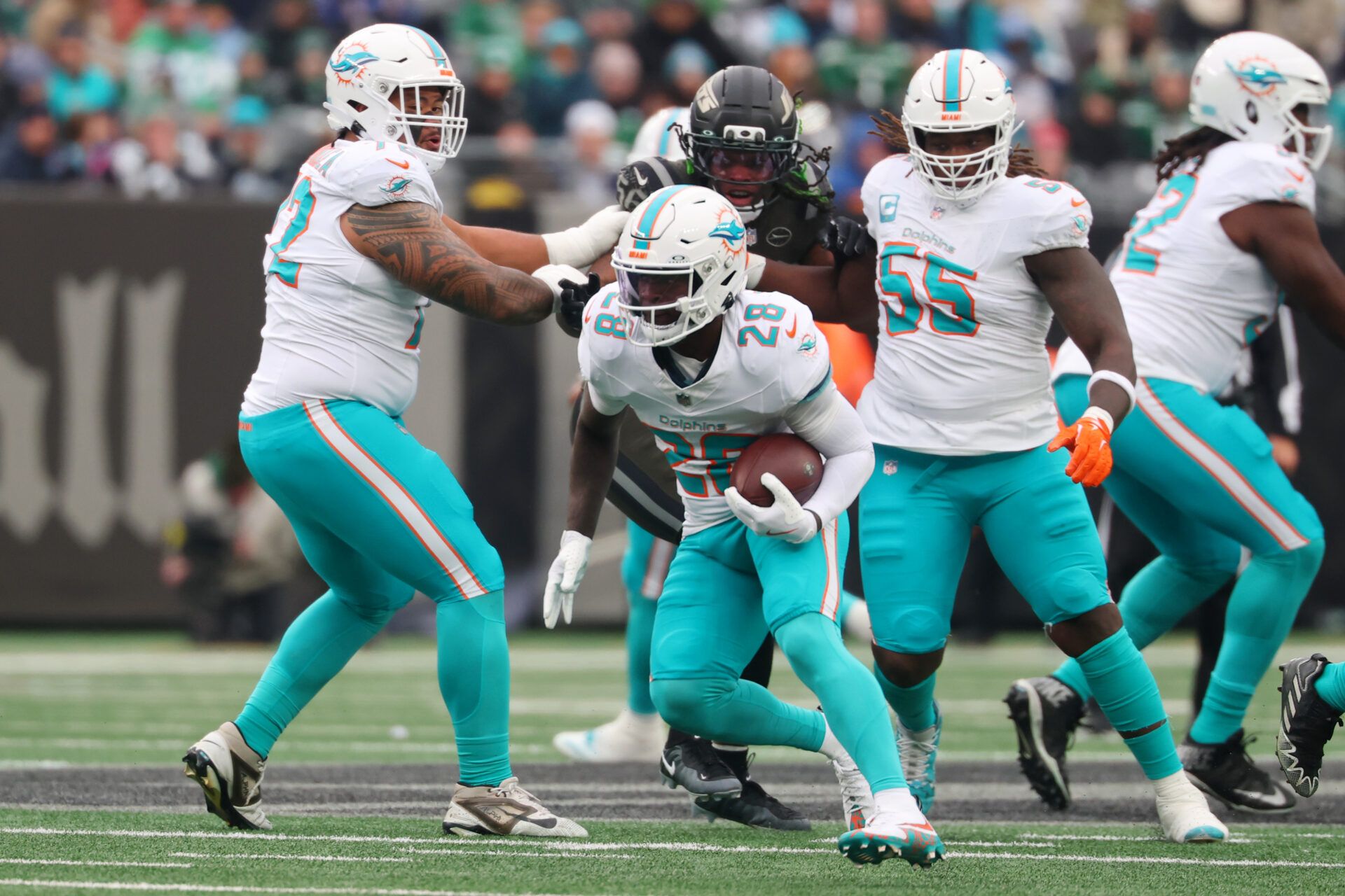 Miami Dolphins running back De'Von Achane (28) runs with the ball against the New York Jets during the first half at MetLife Stadium.