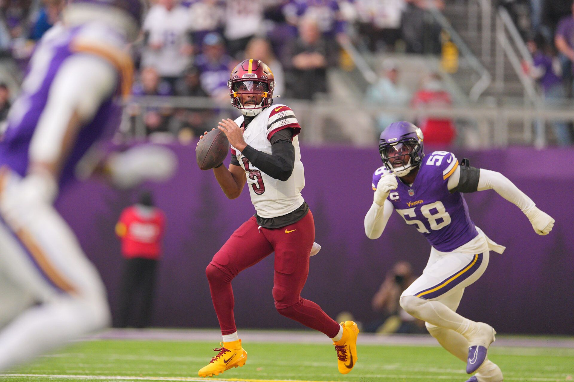 Washington Commanders quarterback Jayden Daniels (5) drops back to pass during the second half at U.S. Bank Stadium.
