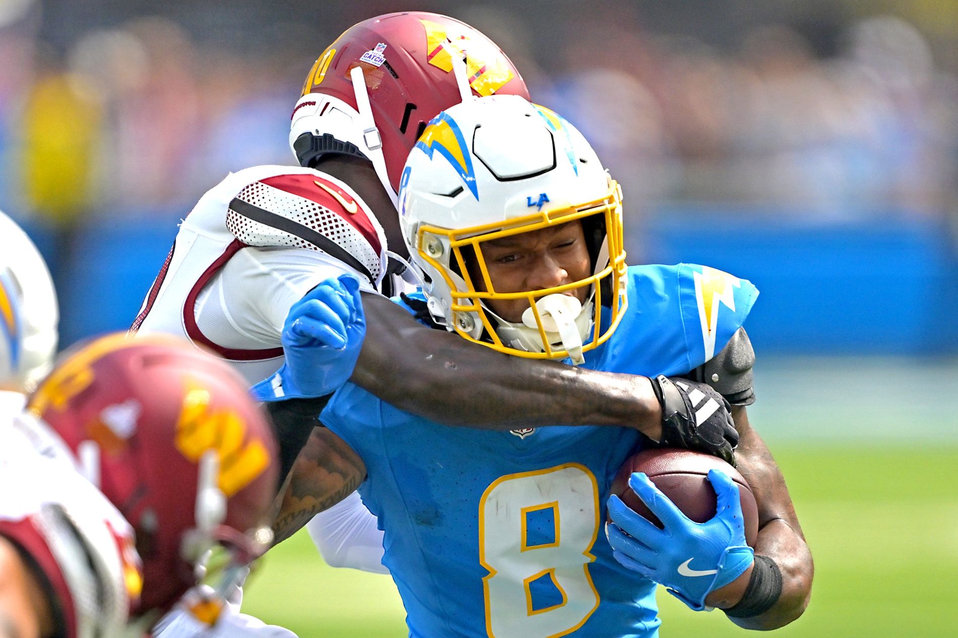 Los Angeles Chargers running back Omarion Hampton (8) is stopped by Washington Commanders safety Quan Martin (20) at SoFi Stadium.