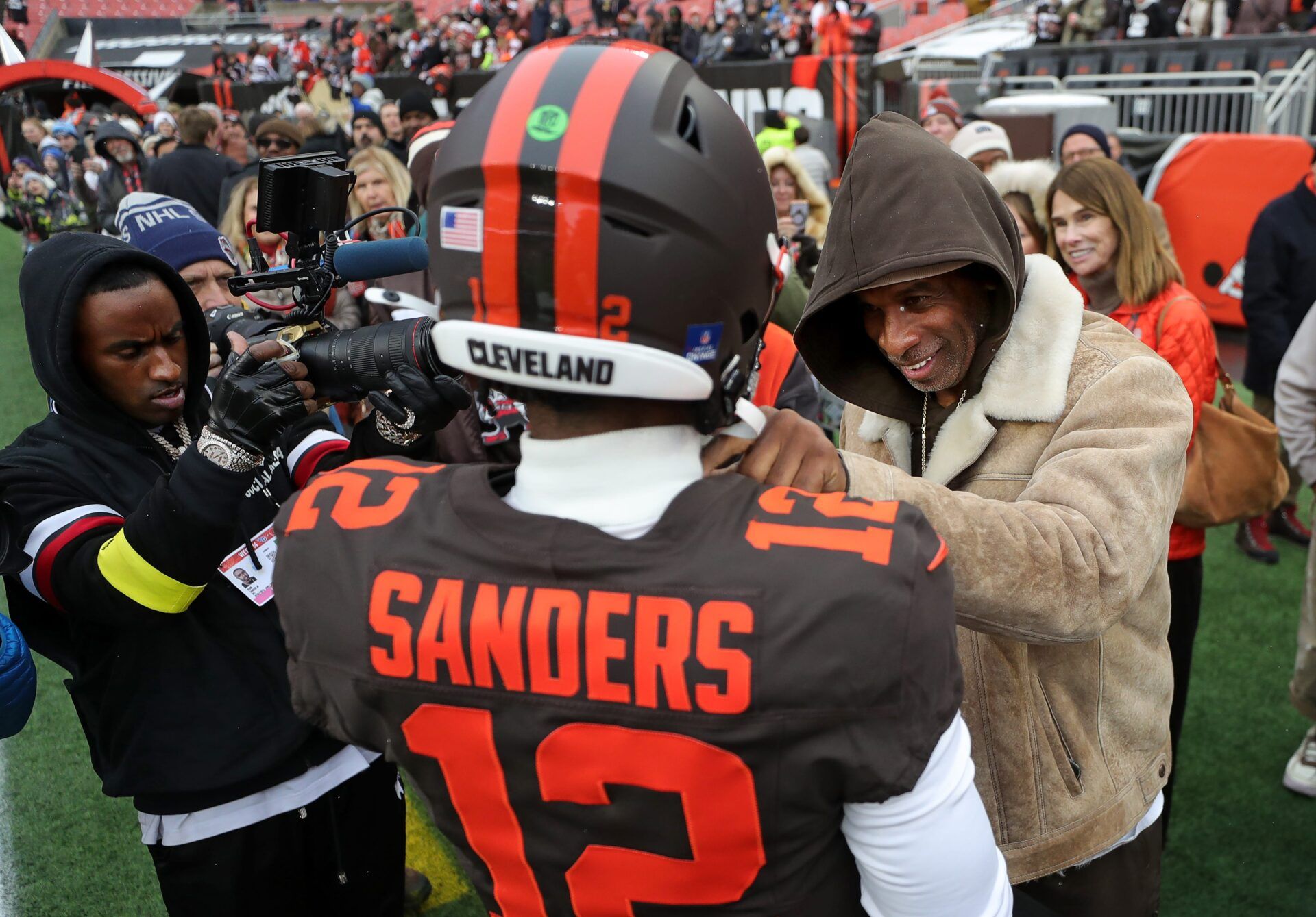NFL legend Deion Sanders, right, gives his son Shedeur Sanders a pep talk before an NFL football game at Huntington Bank Field, Dec. 7, 2025, in Cleveland, Ohio.