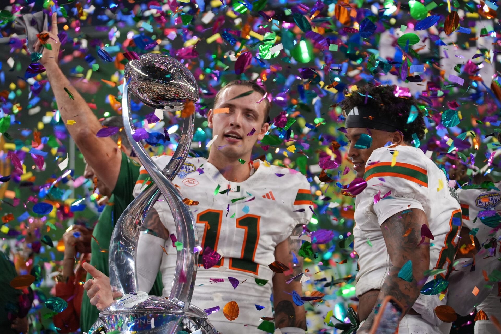 Miami Hurricanes quarterback Carson Beck (11) and defensive back Jakobe Thomas (8) with the champions trophy following the 2025 Cotton Bowl and quarterfinal game of the College Football Playoff against the Ohio State Buckeyes at AT&T Stadium.