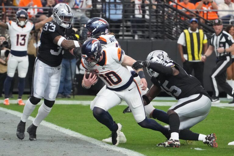 Denver Broncos quarterback Bo Nix (10) carries the ball for a touchdown as Las Vegas Raiders linebacker Devin White (45) defends during the first half at Allegiant Stadium.