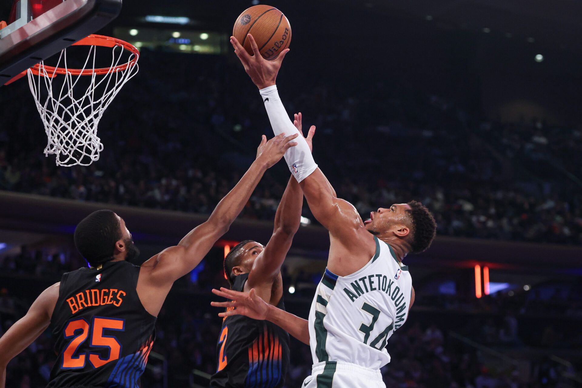 Milwaukee Bucks forward Giannis Antetokounmpo (34) drives to the basket as New York Knicks guard Miles McBride (2) and guard Mikal Bridges (25) defend during the first half at Madison Square Garden.