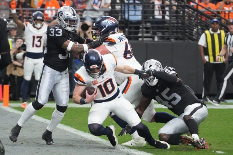 Denver Broncos quarterback Bo Nix (10) carries the ball for a touchdown as Las Vegas Raiders linebacker Devin White (45) defends during the first half at Allegiant Stadium.