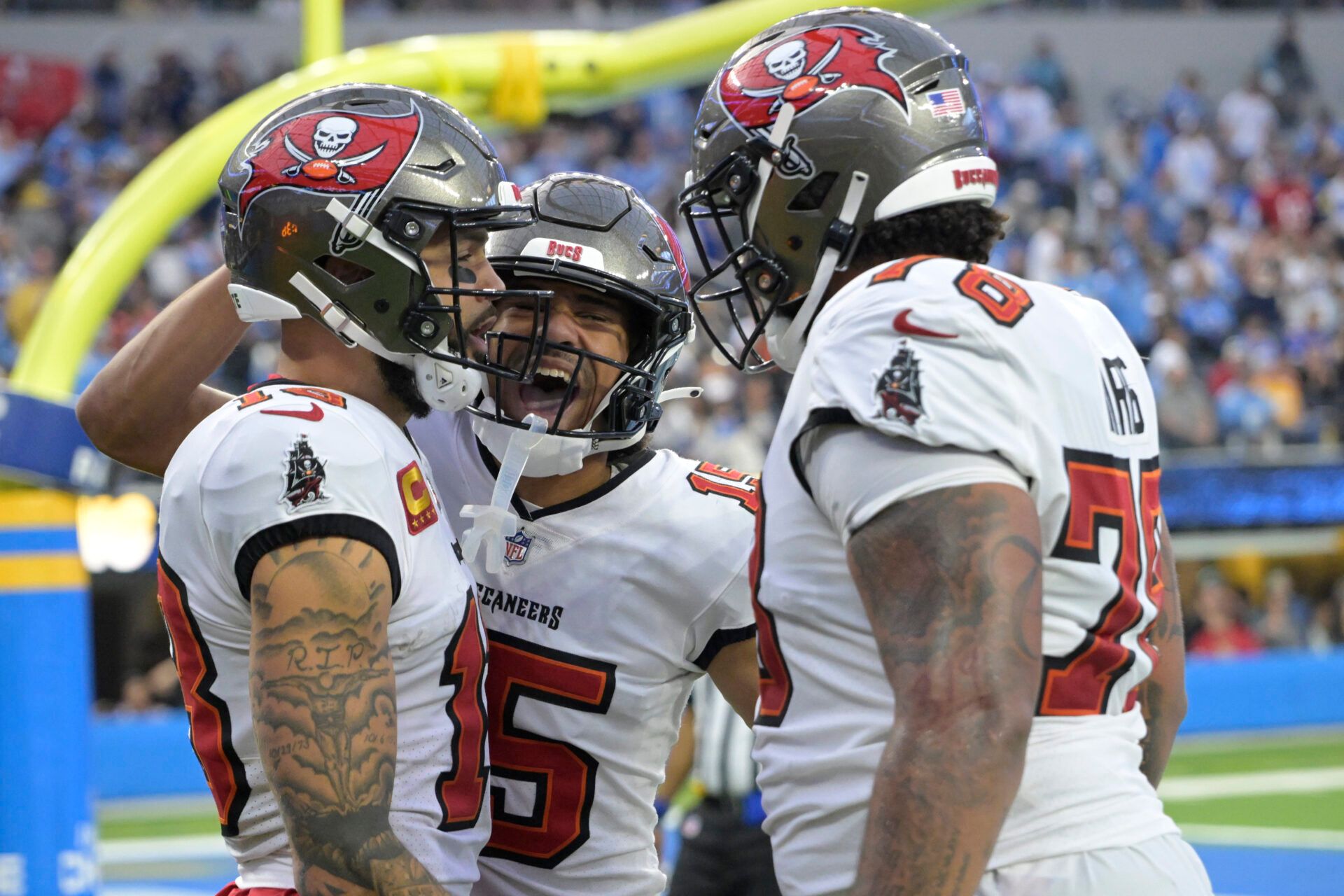 Tampa Bay Buccaneers wide receiver Mike Evans (13) is congratulated by wide receiver Jalen McMillan (15) and offensive tackle Tristan Wirfs (78) after a touchdown in the second half against the Los Angeles Chargers at SoFi Stadium.