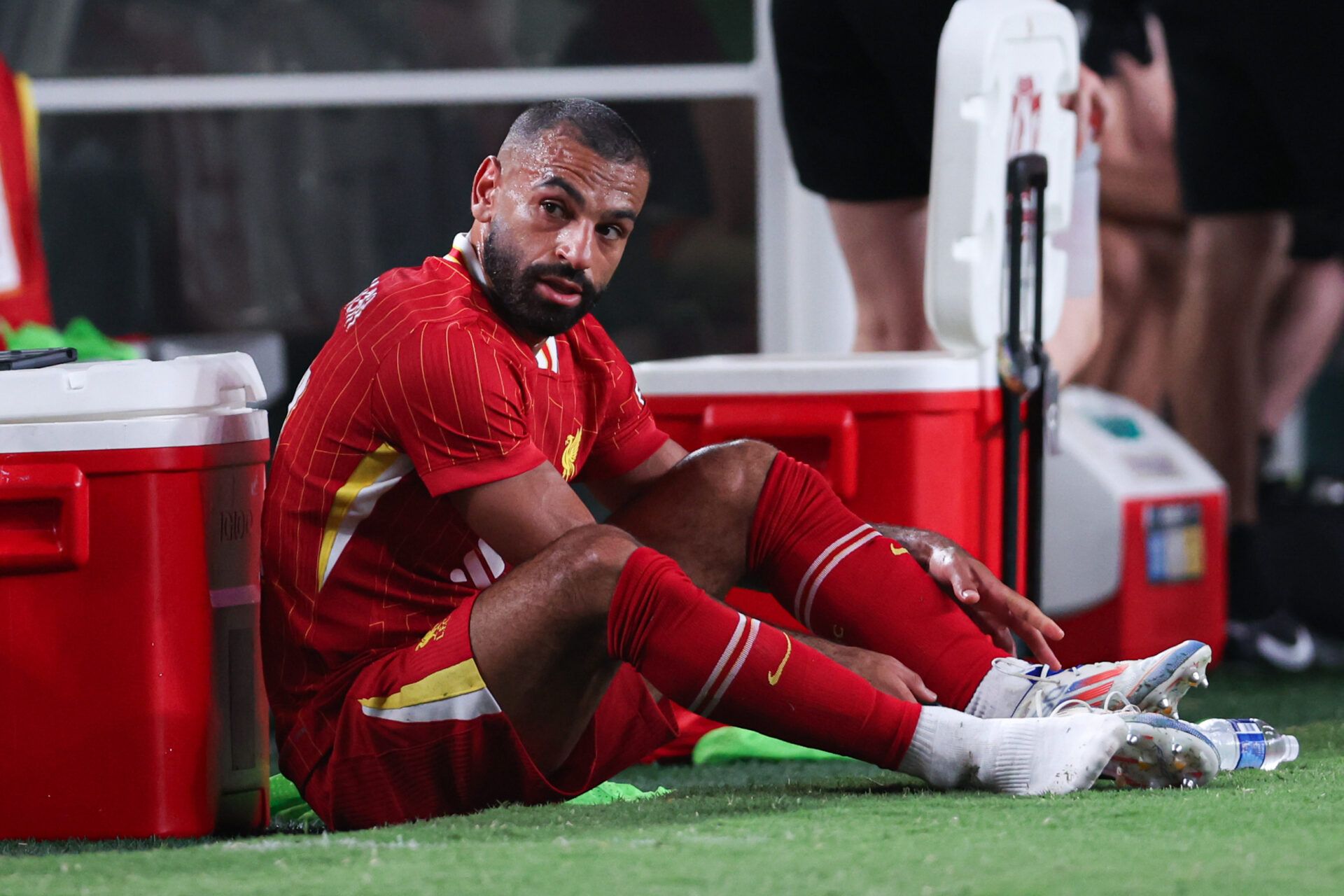 Liverpool forward Mohamed Salah (11) removes his cleats after being subbed out during the second half against Arsenal at Lincoln Financial Field.