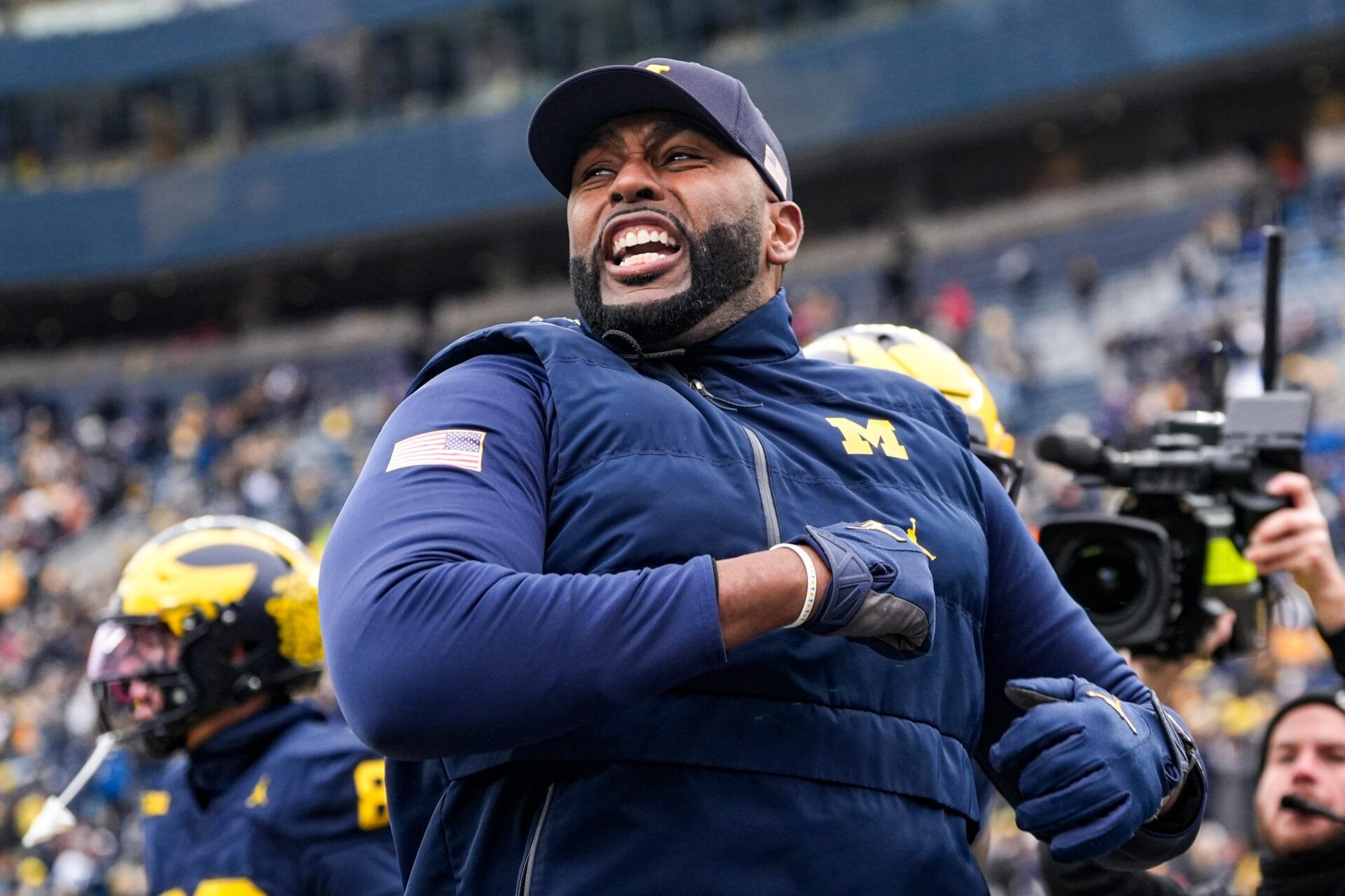 Michigan head coach Sherrone Moore cheer on as he runs onto the filed for warmup at Michigan Stadium in Ann Arbor on Saturday, Nov. 29, 2025.