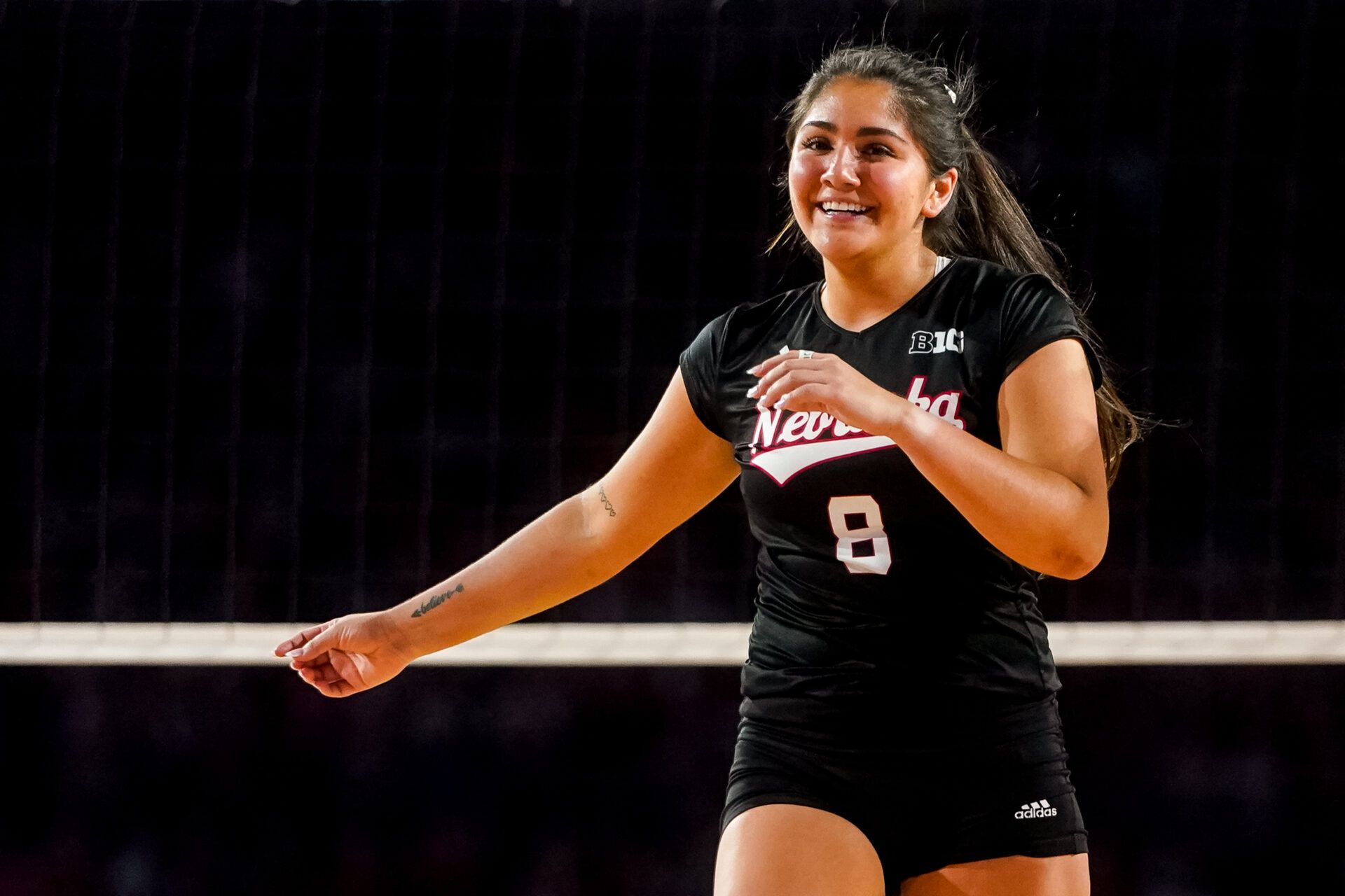 Nebraska Cornhuskers libero Lexi Rodriguez (8) smiles after the Cornhuskers scored against the Omaha Mavericks during the third set at Memorial Stadium.