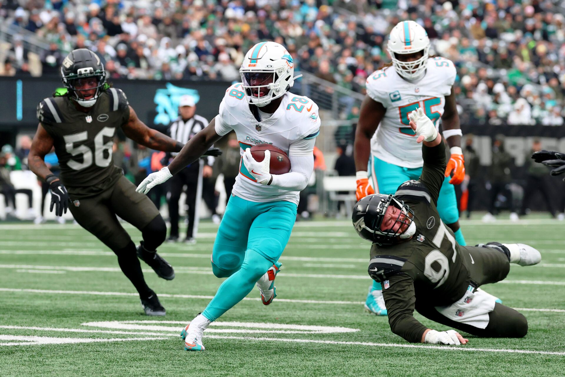 Miami Dolphins running back De'Von Achane (28) runs with the ball against the New York Jets during the first half at MetLife Stadium.
