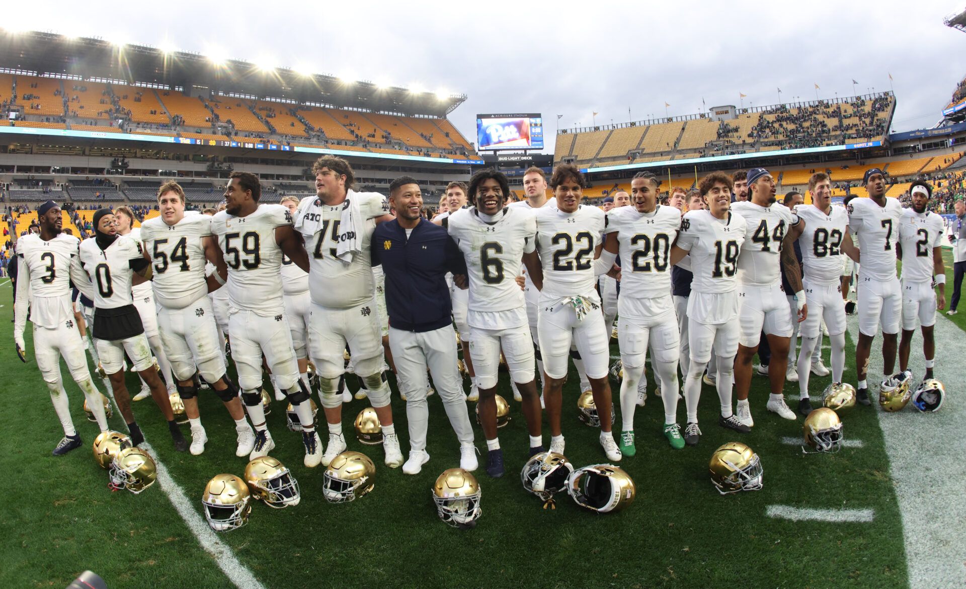 Notre Dame Fighting Irish head coach Marcus Freeman (middle) joins his players in singing the victory song after defeating the Pittsburgh Panthers at Acrisure Stadium.
