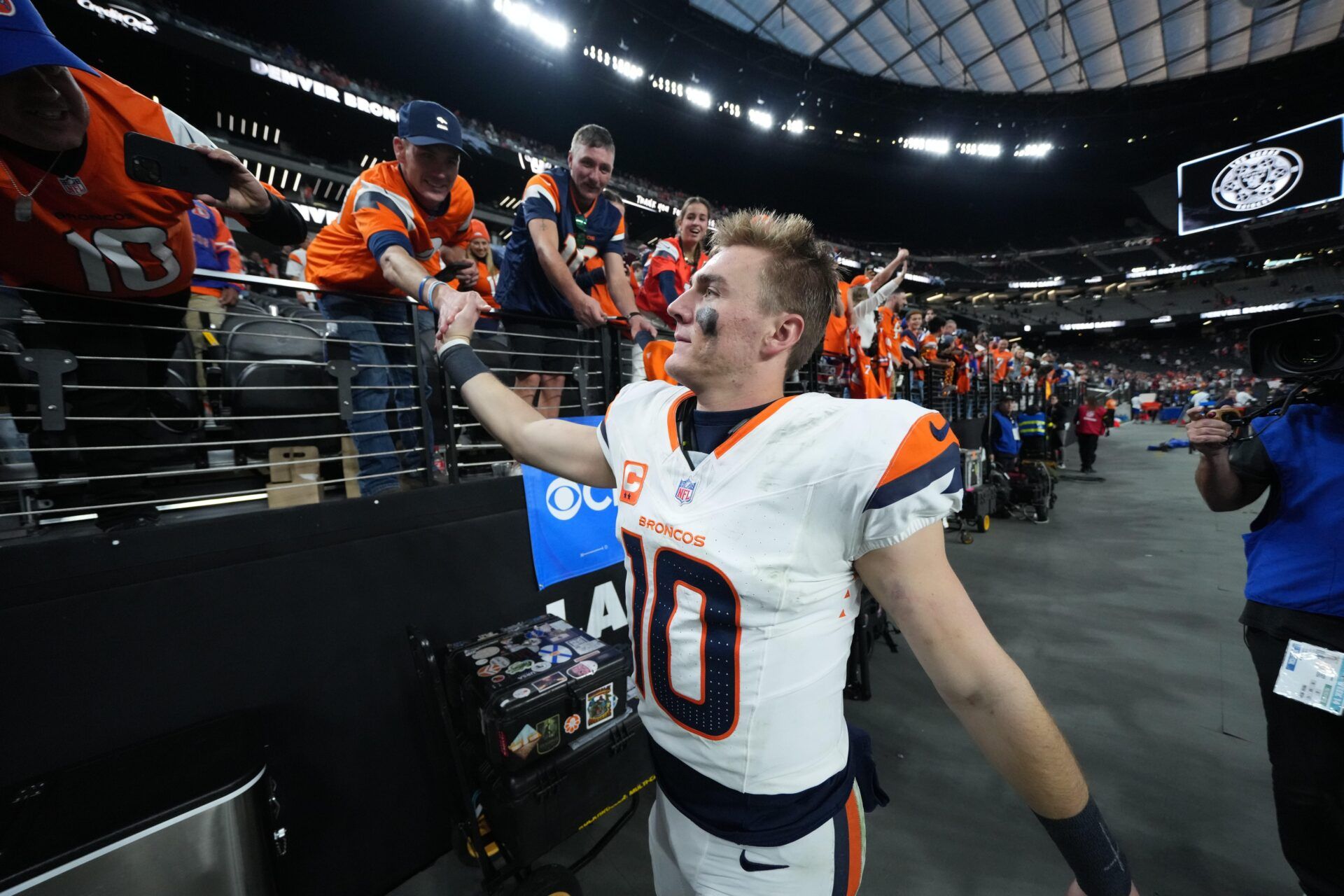 Denver Broncos quarterback Bo Nix (10) high five fans following a game against the Las Vegas Raiders  at Allegiant Stadium.