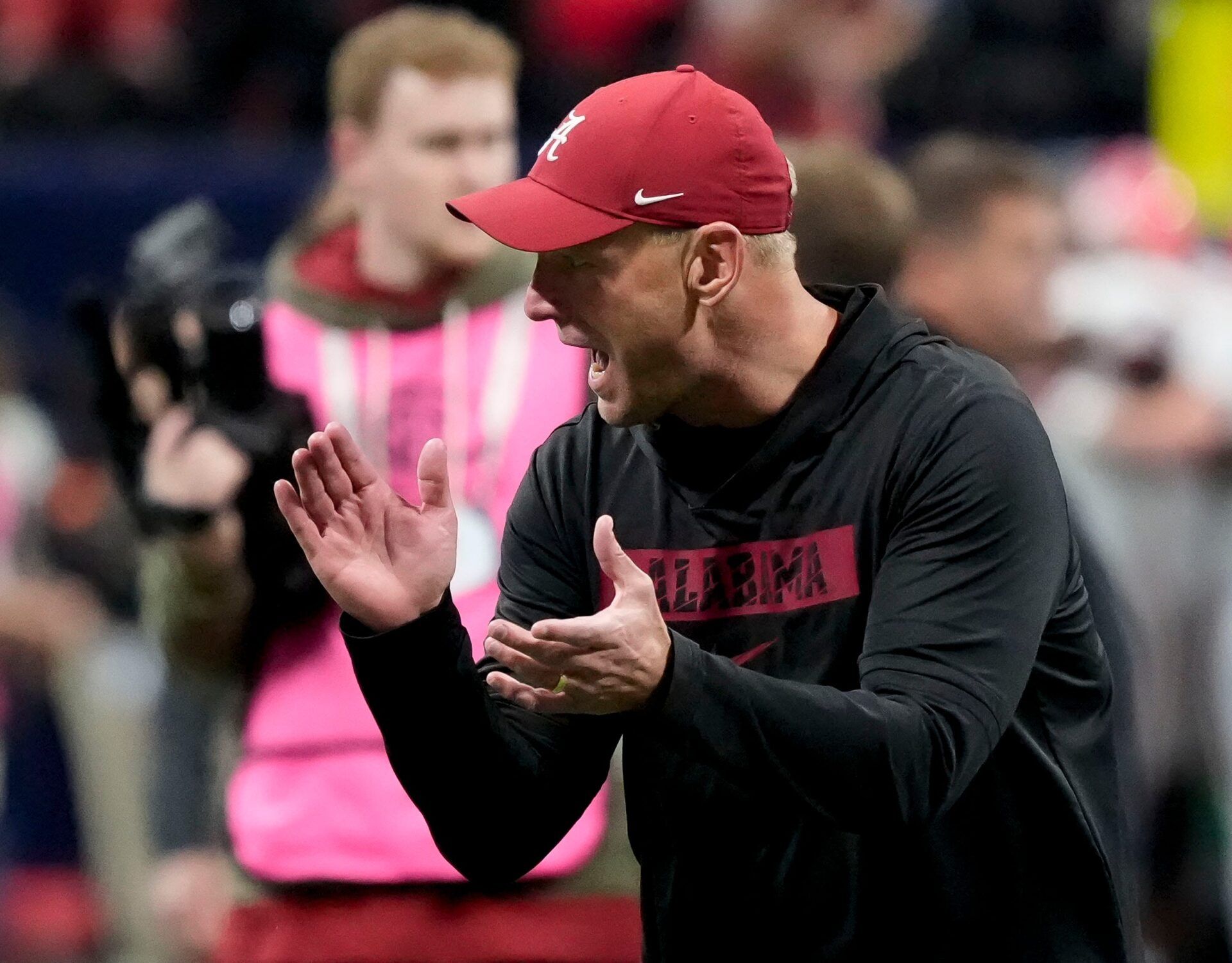 Alabama head coach Kalen DeBoer encourages his players as they warm up before the SEC Championship Game at Mercedes-Benz Stadium.