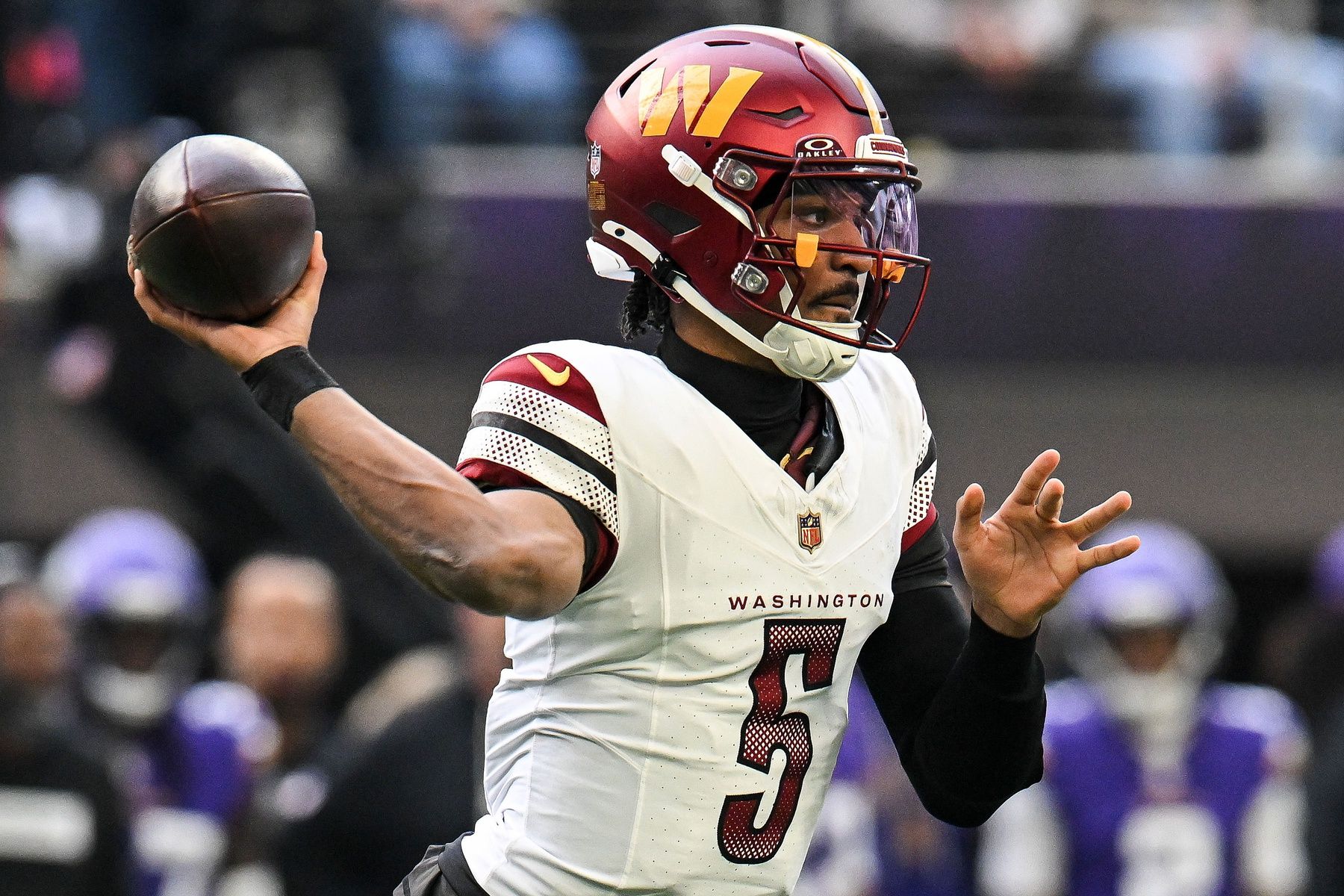 Washington Commanders quarterback Jayden Daniels (5) drops back to pass against the Minnesota Vikings during the first half at U.S. Bank Stadium.