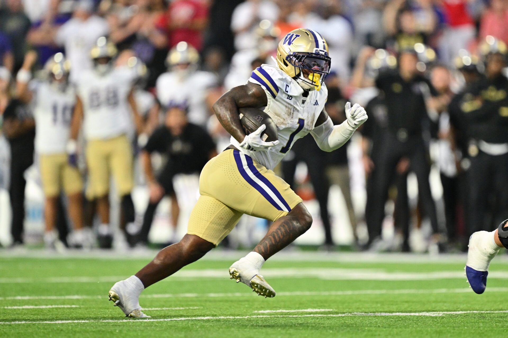 Washington Huskies running back Jonah Coleman (1) carries the ball against the Maryland Terrapins at SECU Stadium.