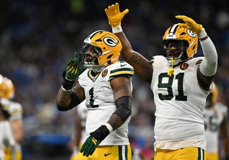 Green Bay Packers defensive end Micah Parsons (1) and Green Bay Packers defensive tackle Warren Brinson (91) celebrate after a play against the Detroit Lions during the first quarter at Ford Field.