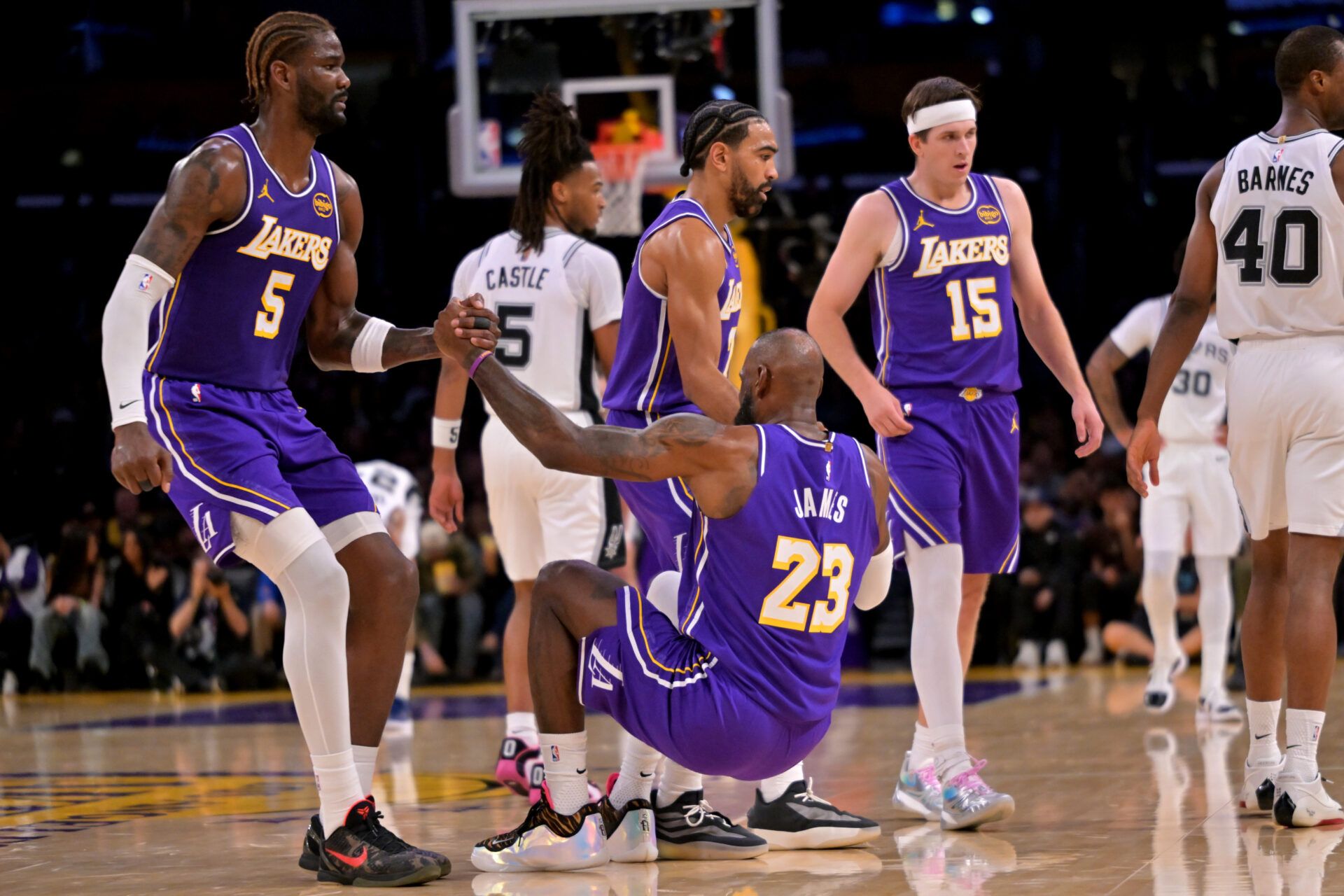 Los Angeles Lakers forward Lebron James (23) gets a hand from center Deandre Ayton (5) and guard Gabe Vincent (7) after he was knocked to the floor during the first half against the San Antonio Spurs at Crypto.com Arena.
