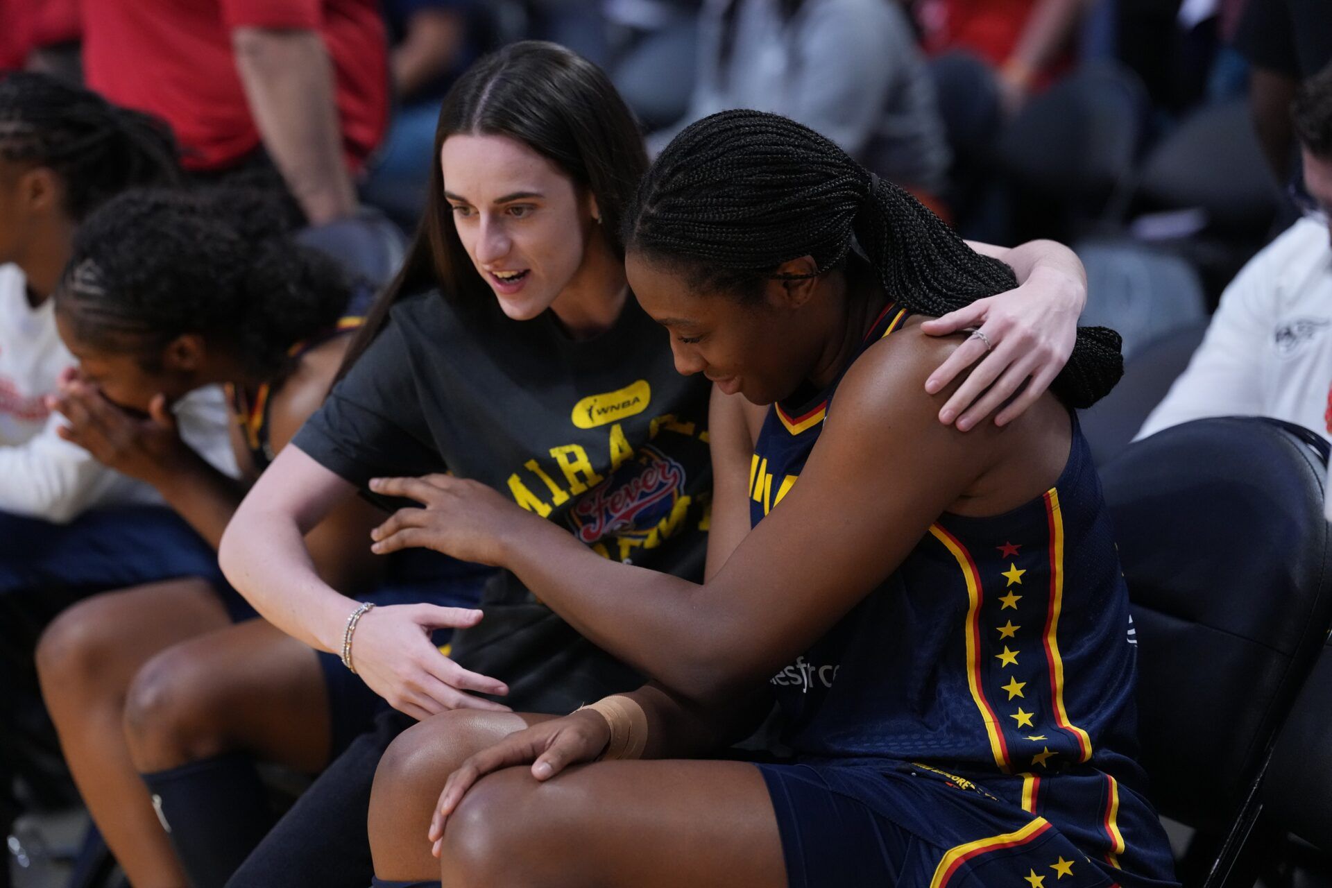 Indiana Fever guard Caitlin Clark (22) puts her arm around forward Aliyah Boston (7) in the first half against the LA Sparks at Crypto.com Arena.