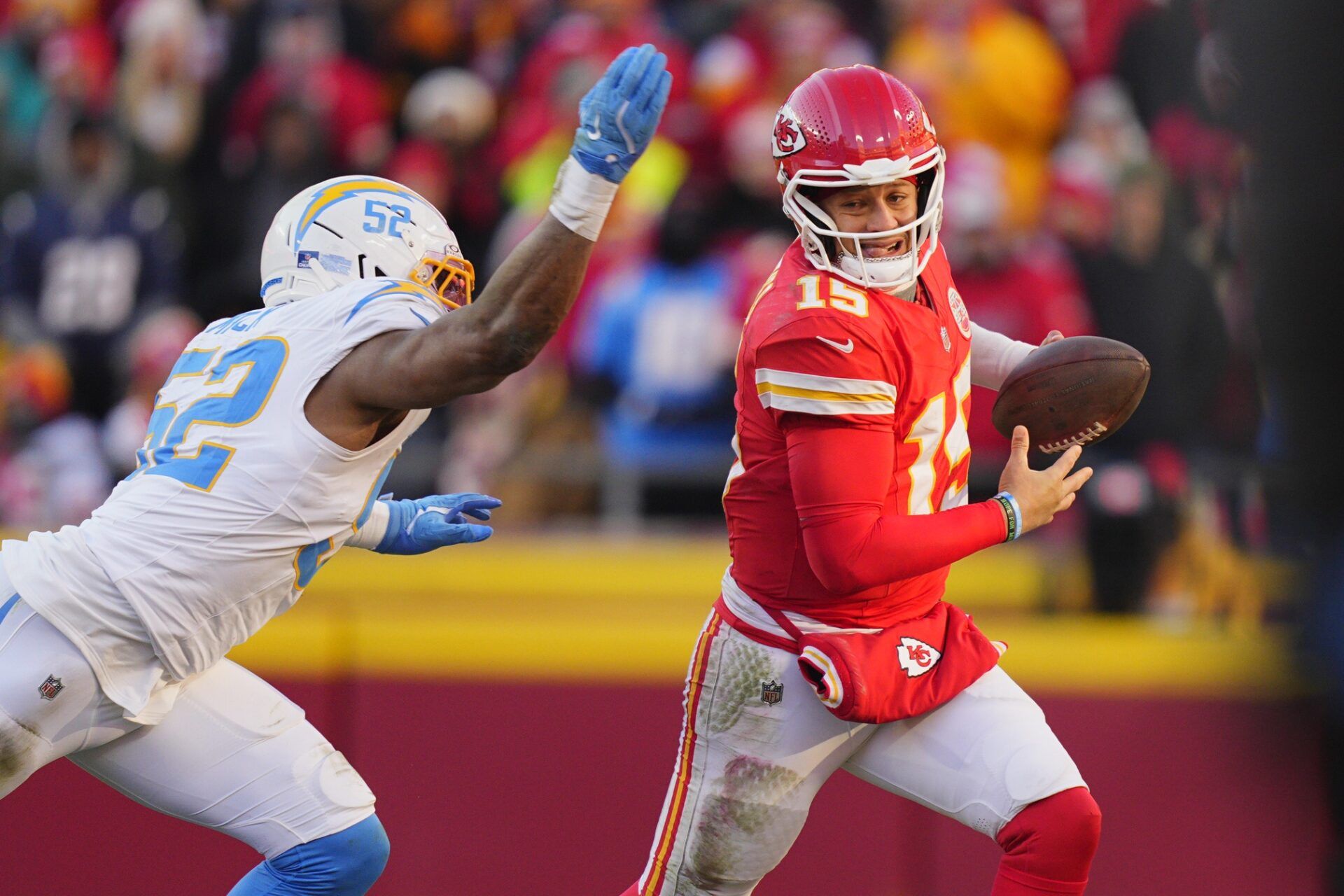 Kansas City Chiefs quarterback Patrick Mahomes (15) scrambles against Los Angeles Chargers linebacker Khalil Mack (52) during the second half at GEHA Field at Arrowhead Stadium.