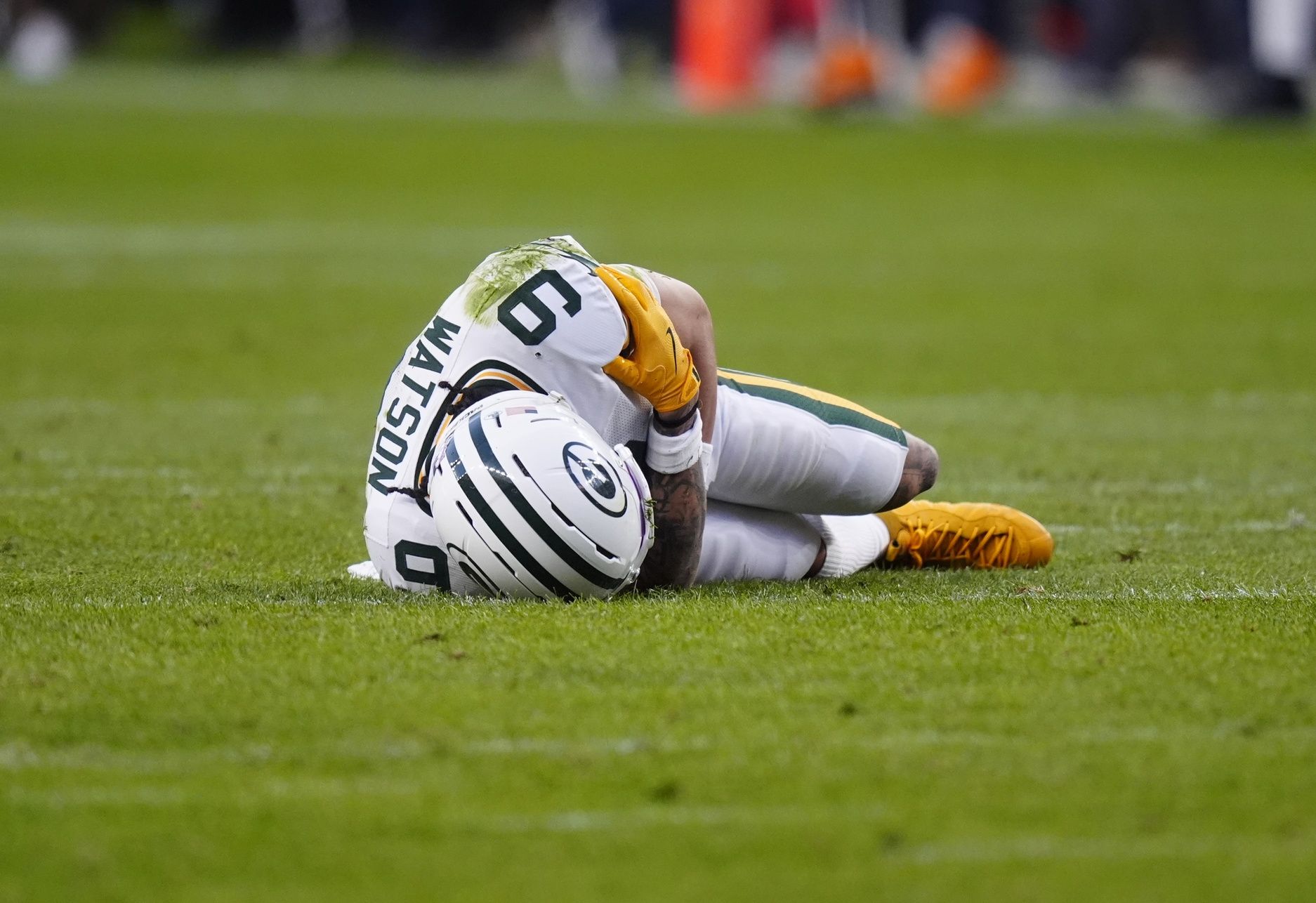 Green Bay Packers wide receiver Christian Watson (9) lies on the field following an injury during the third quarter against the Denver Broncos at Empower Field at Mile High.