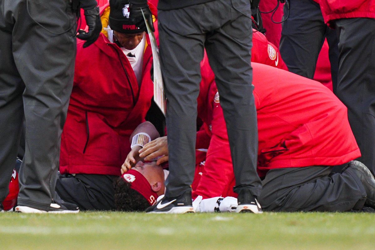 Kansas City Chiefs quarterback Patrick Mahomes (15) is attended to by team medical staff following an injury during the fourth quarter against the Los Angeles Chargers at GEHA Field at Arrowhead Stadium.
