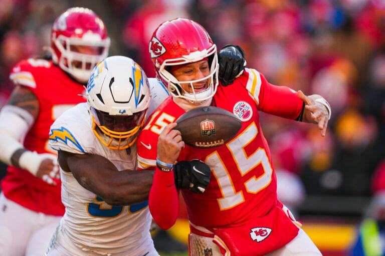 Los Angeles Chargers linebacker Odafe Oweh (98) sacks Kansas City Chiefs quarterback Patrick Mahomes (15) during the second half at GEHA Field at Arrowhead Stadium.