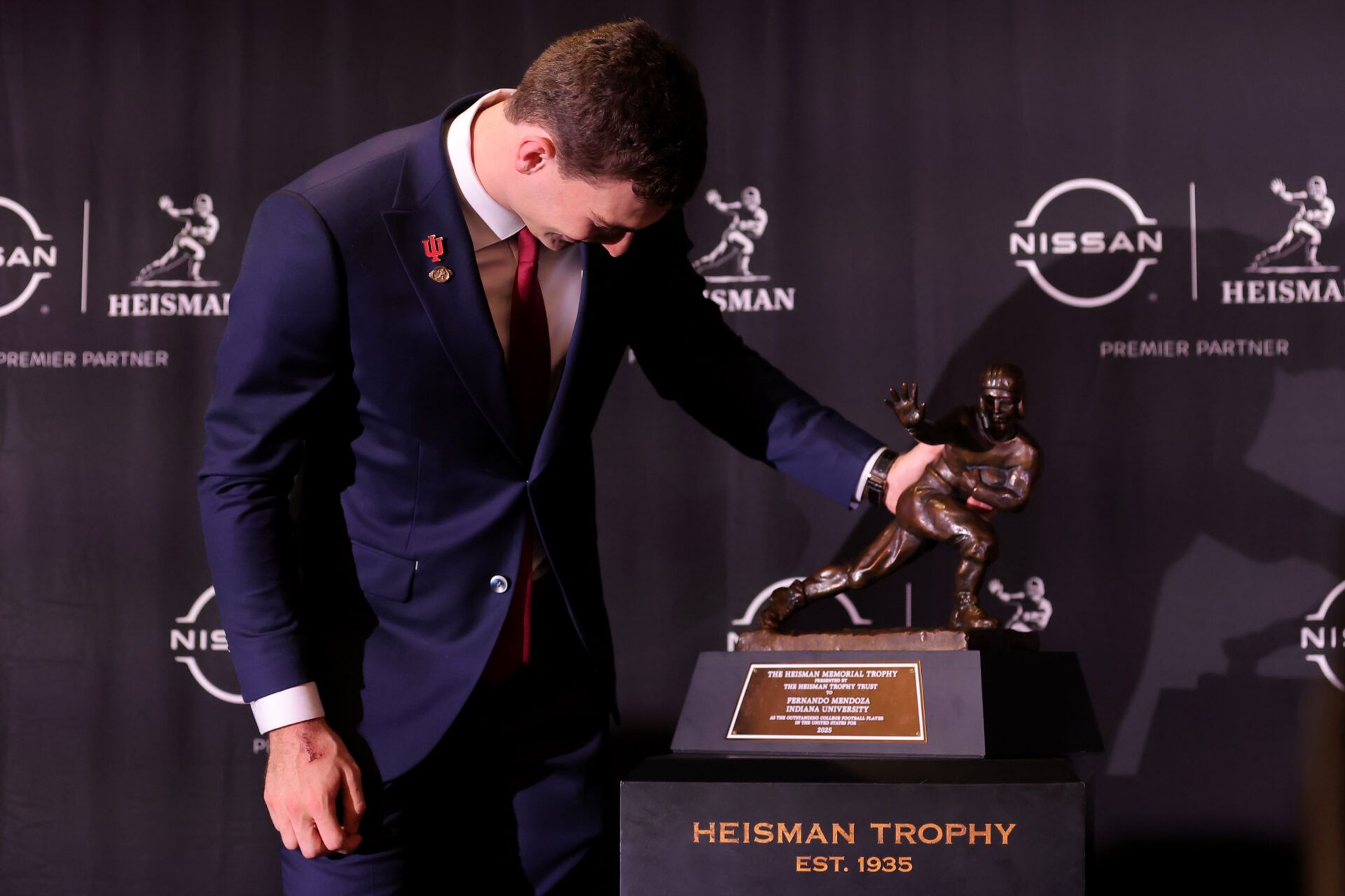 Indiana Hoosiers quarterback Fernando Mendoza looks at his name on the nameplate of the Heisman trophy during a press conference at the New York Marriott Marquis after winning the award.