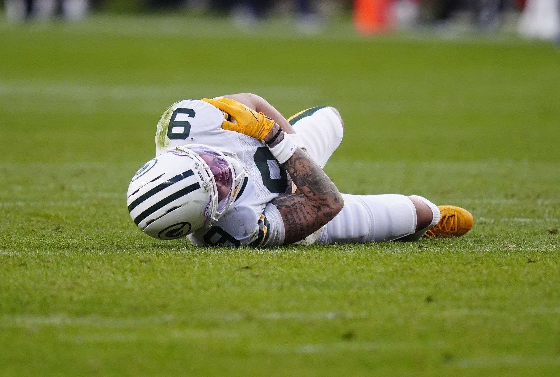 Green Bay Packers wide receiver Christian Watson (9) lies on the field following an injury during the third quarter against the Denver Broncos at Empower Field at Mile High.