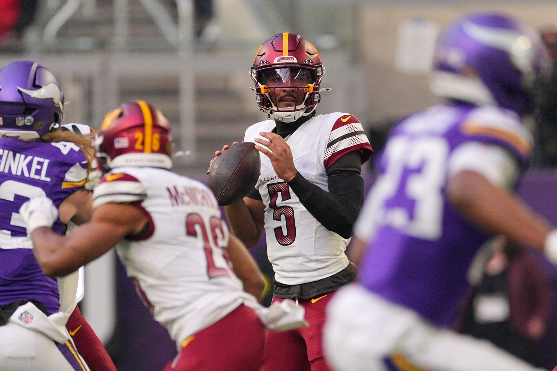Washington Commanders quarterback Jayden Daniels (5) drops back to pass against the Minnesota Vikings during the first half at U.S. Bank Stadium.