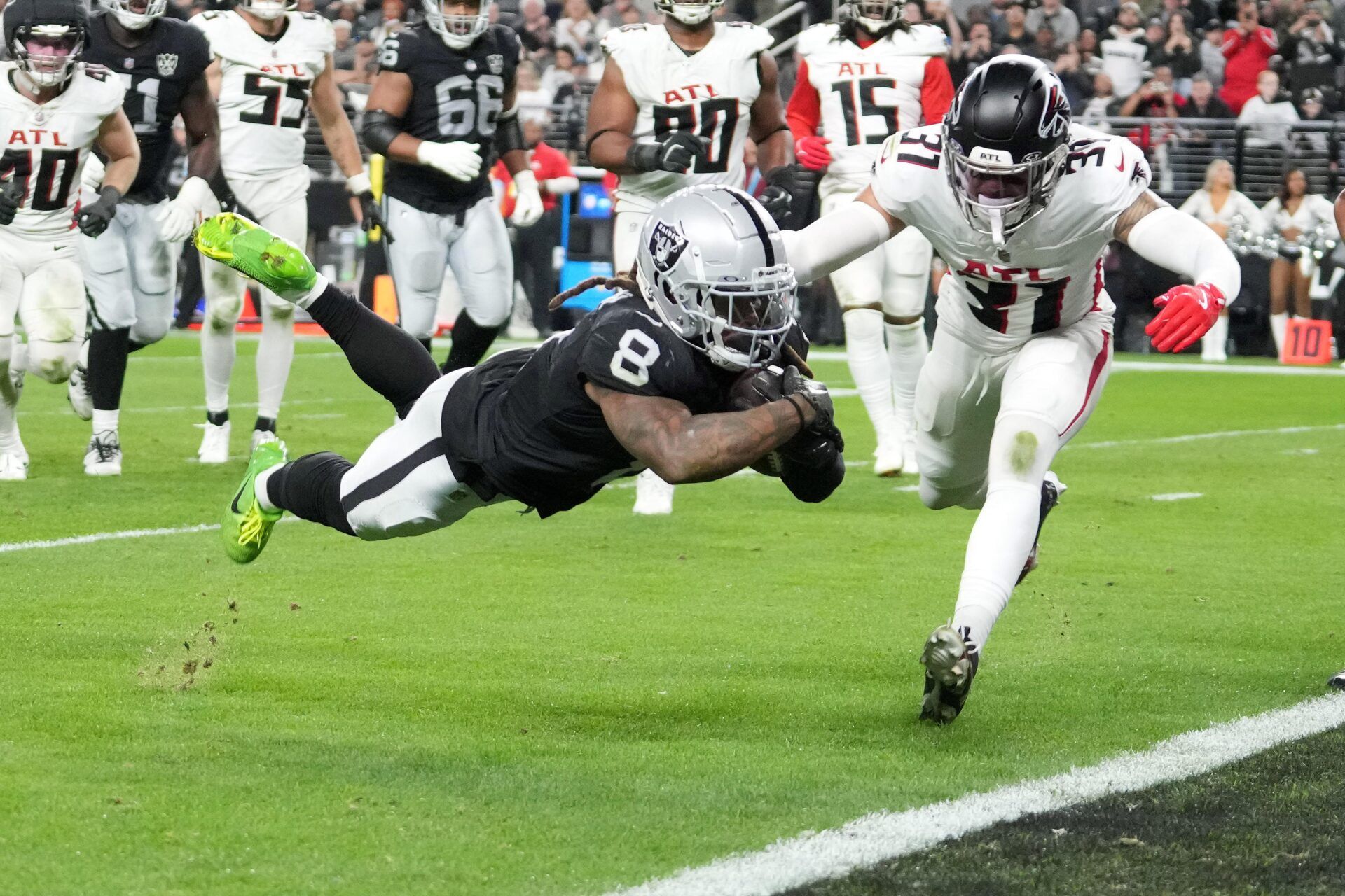 Las Vegas Raiders running back Ameer Abdullah (8) scores on a 5-yard touchdown reception against Atlanta Falcons safety Justin Simmons (31) in the fourth quarter at Allegiant Stadium.