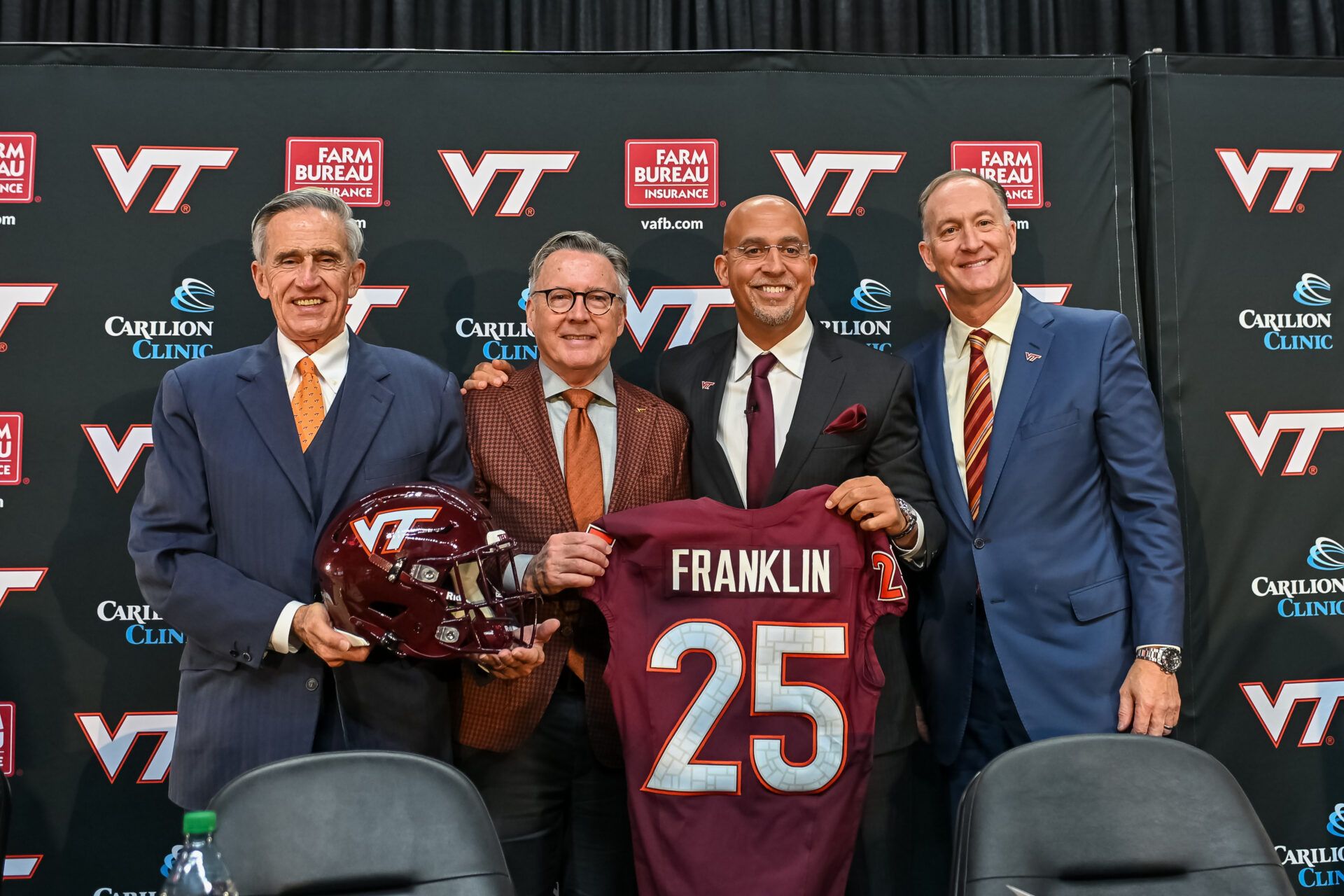 L-R, John Rocovich, Timothy Sands, James Franklin and Whit Babcock hold up a Virginia Tech jersey during the press conference celebrating Franklin as head coach at Cassell Coliseum.