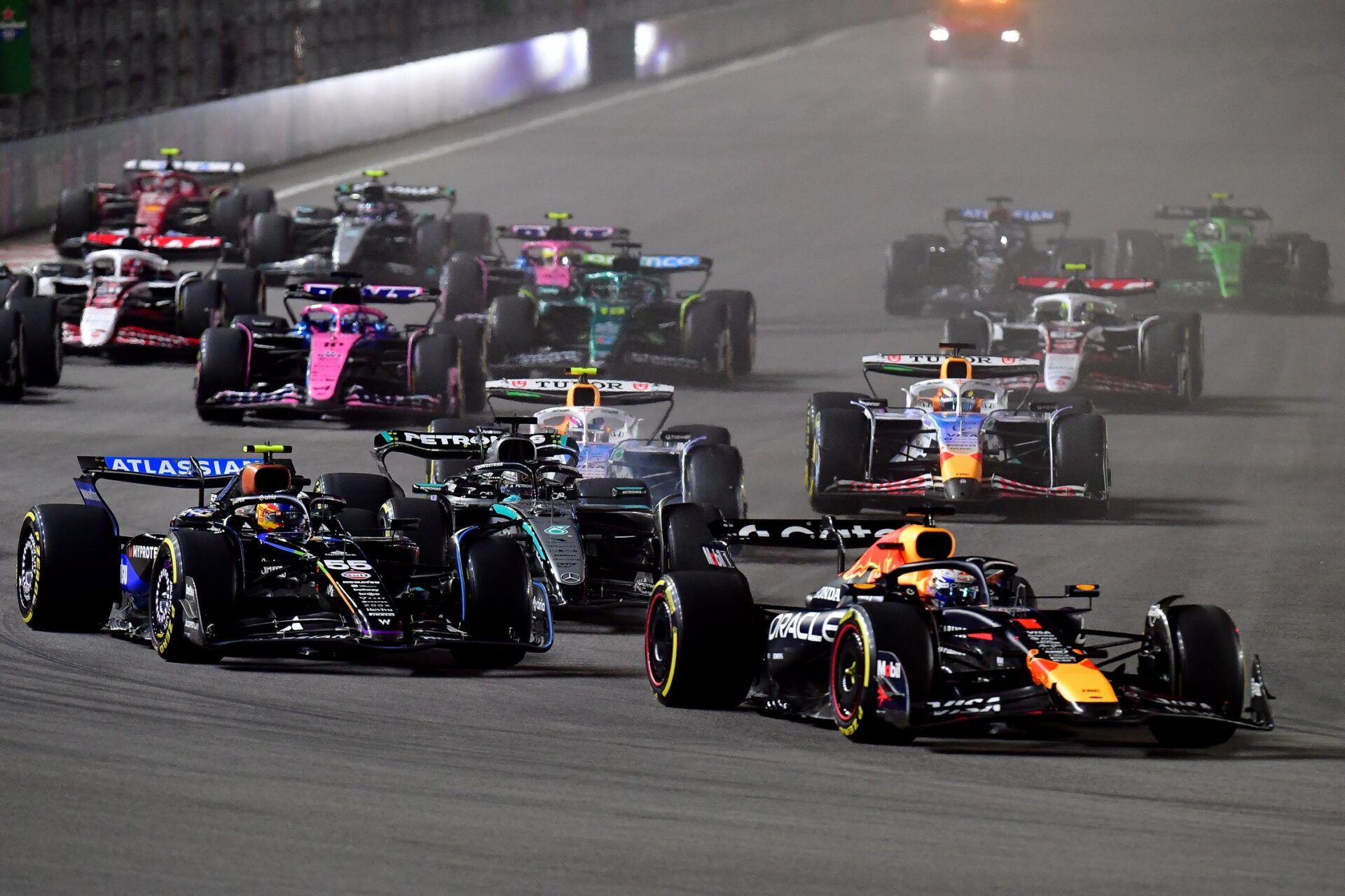 Red Bull Racing driver Max Verstappen (1) leads Williams driver Carlos Sainz (55) and the rest of the field during the opening laps of the Las Vegas Grand Prix at Las Vegas Strip Circuit.