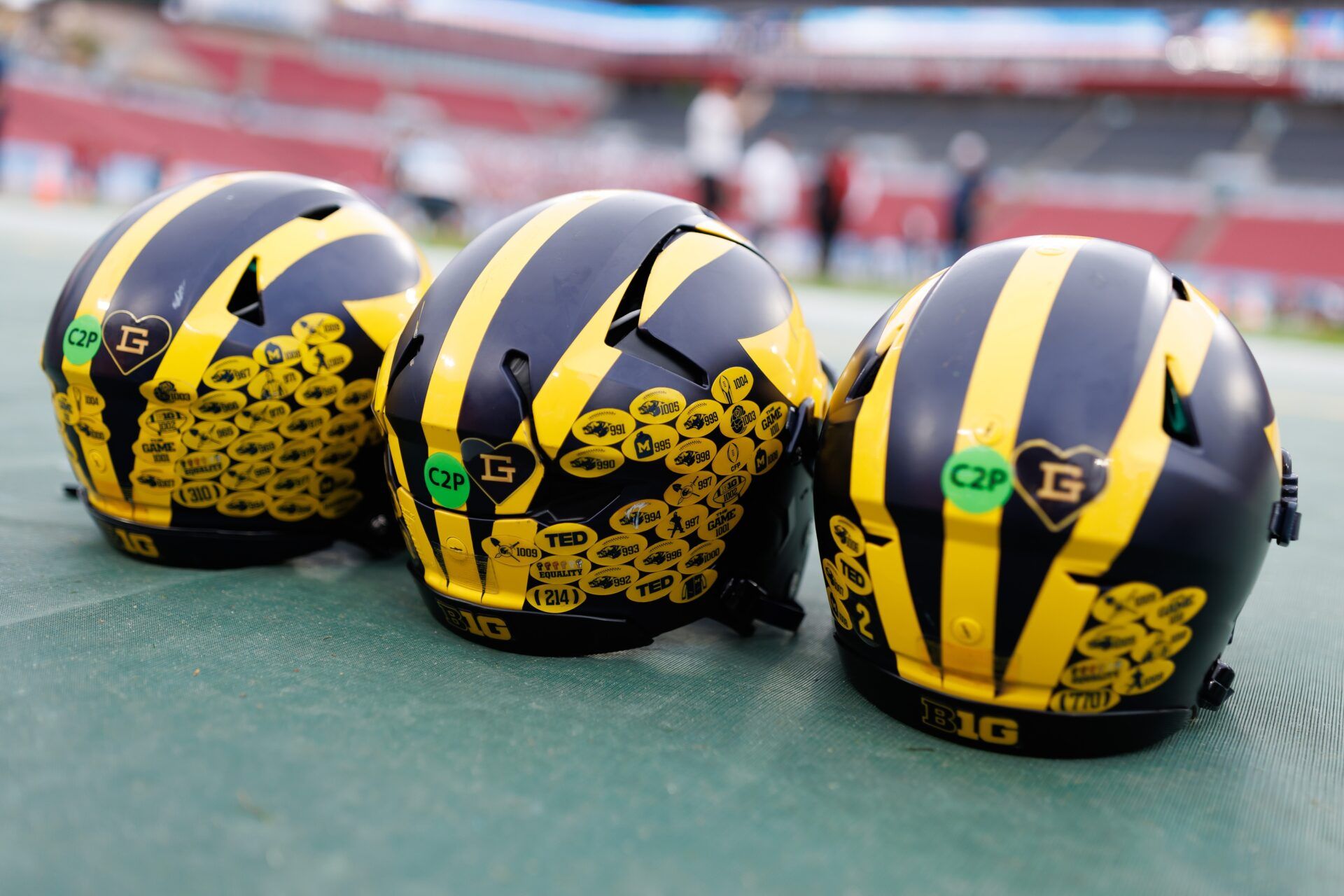 Michigan Wolverines quarterback helmets sit on the field before a game against the Alabama Crimson Tide at Raymond James Stadium.