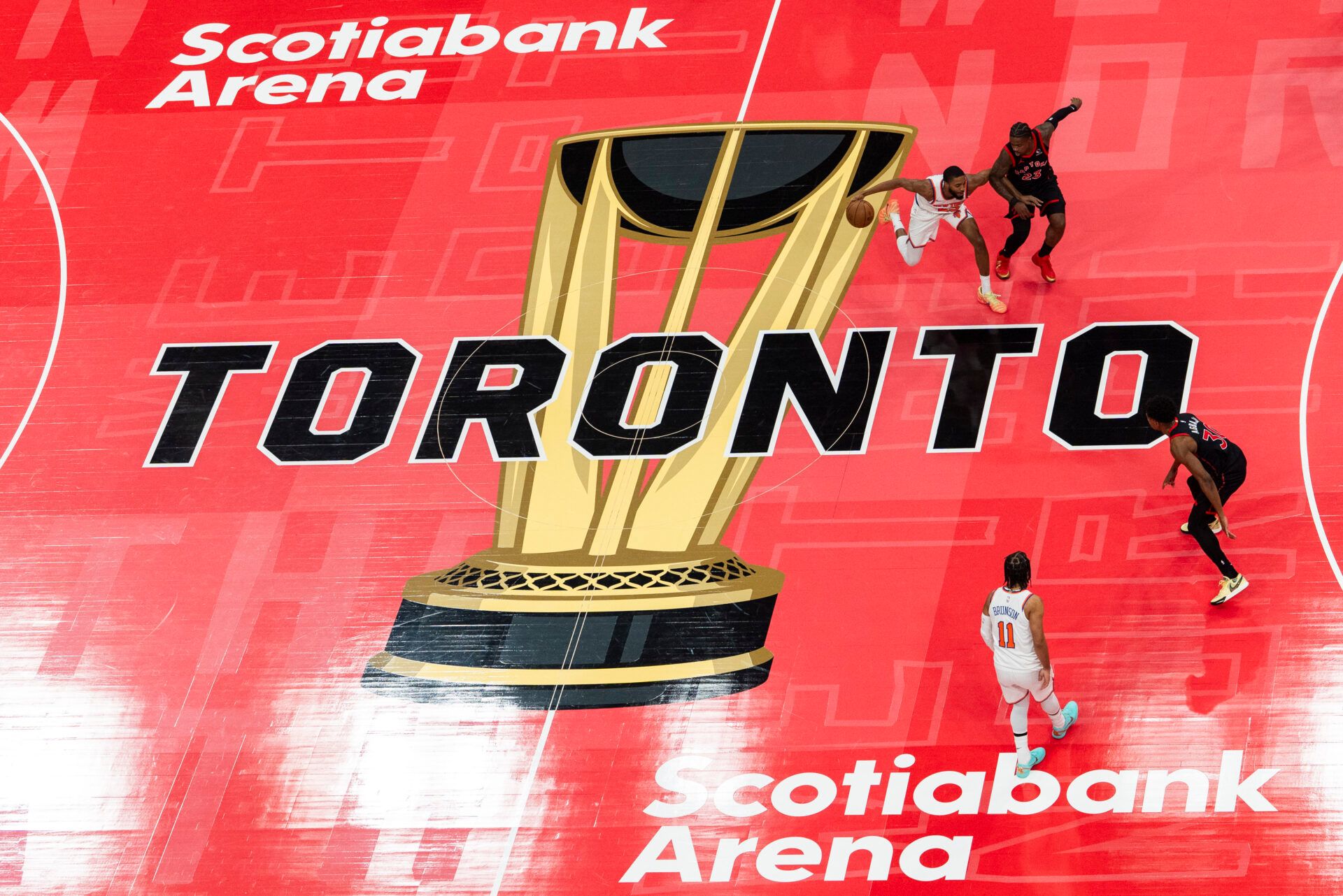 New York Knicks guard Mikal Bridges (25) dribbles against Toronto Raptors guard Jamal Shead (23) during the first half at the 2025-26 NBA Emirates Cup at Scotiabank Arena.
