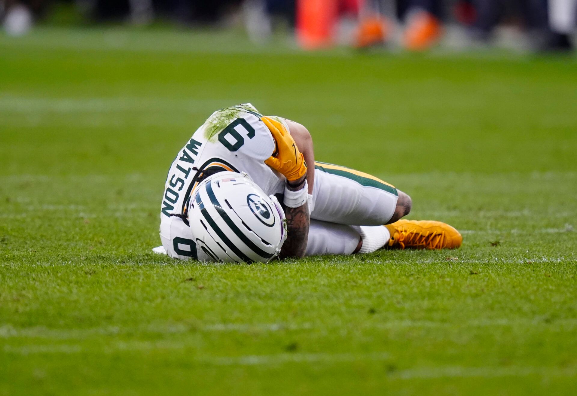 Green Bay Packers wide receiver Christian Watson (9) lies on the field following an injury during the third quarter against the Denver Broncos at Empower Field at Mile High.