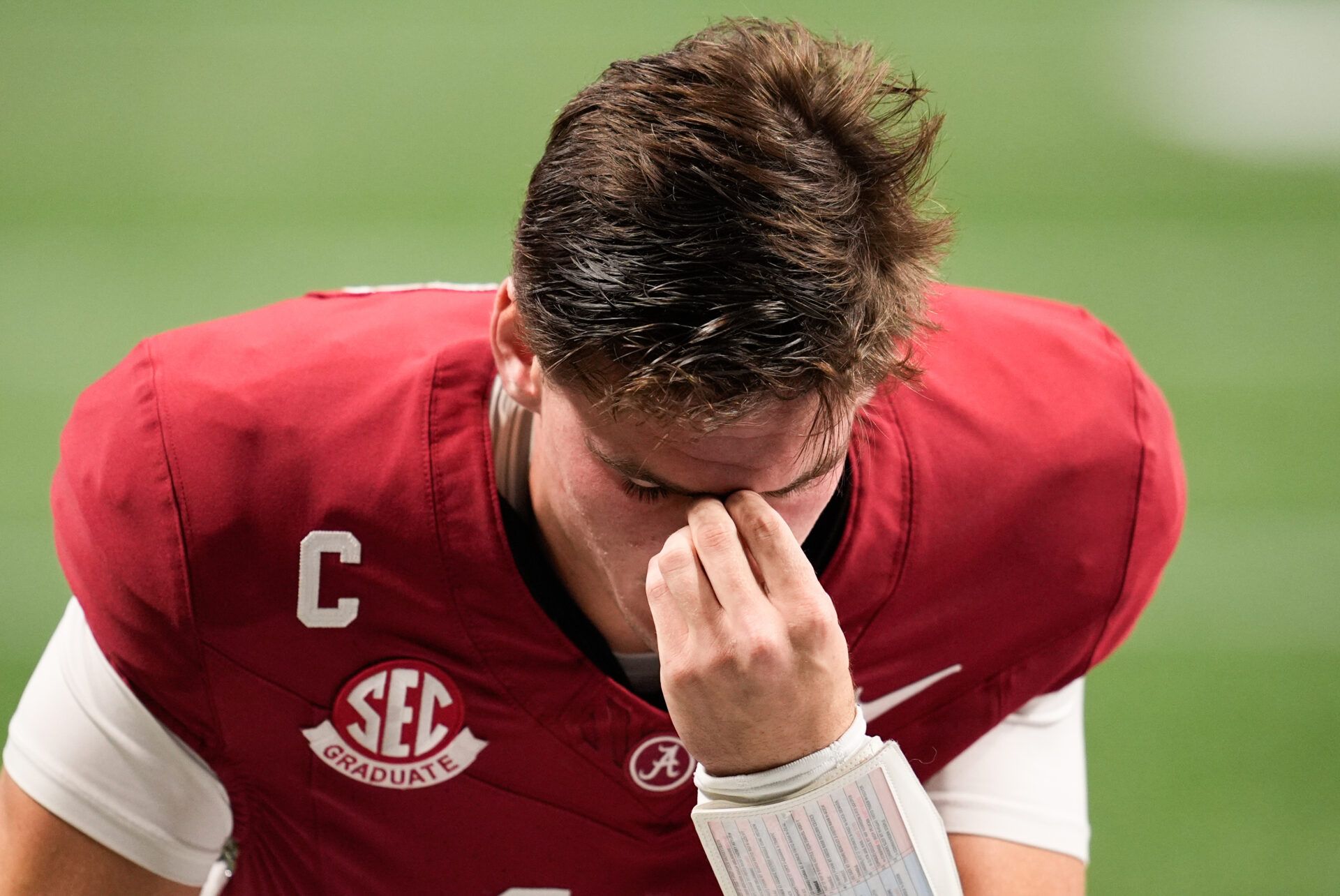 Alabama Crimson Tide quarterback Ty Simpson (15) kneels before the game against the Georgia Bulldogs during the 2025 SEC Championship game at Mercedes-Benz Stadium.