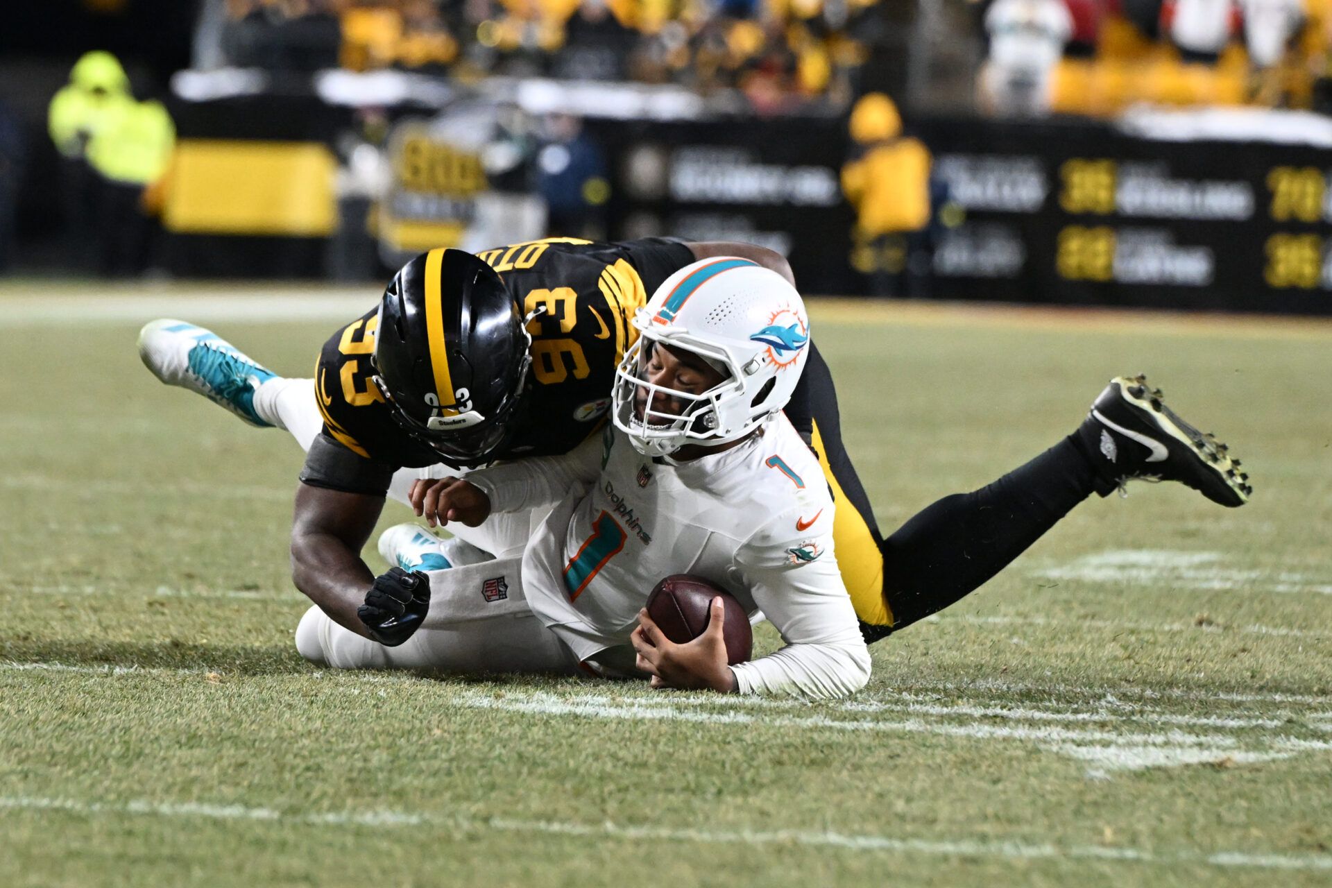 Miami Dolphins quarterback Tua Tagovailoa (1) is sacked by Pittsburgh Steelers defensive end Esezi Otomewo (93) in the fourth quarter at Acrisure Stadium.