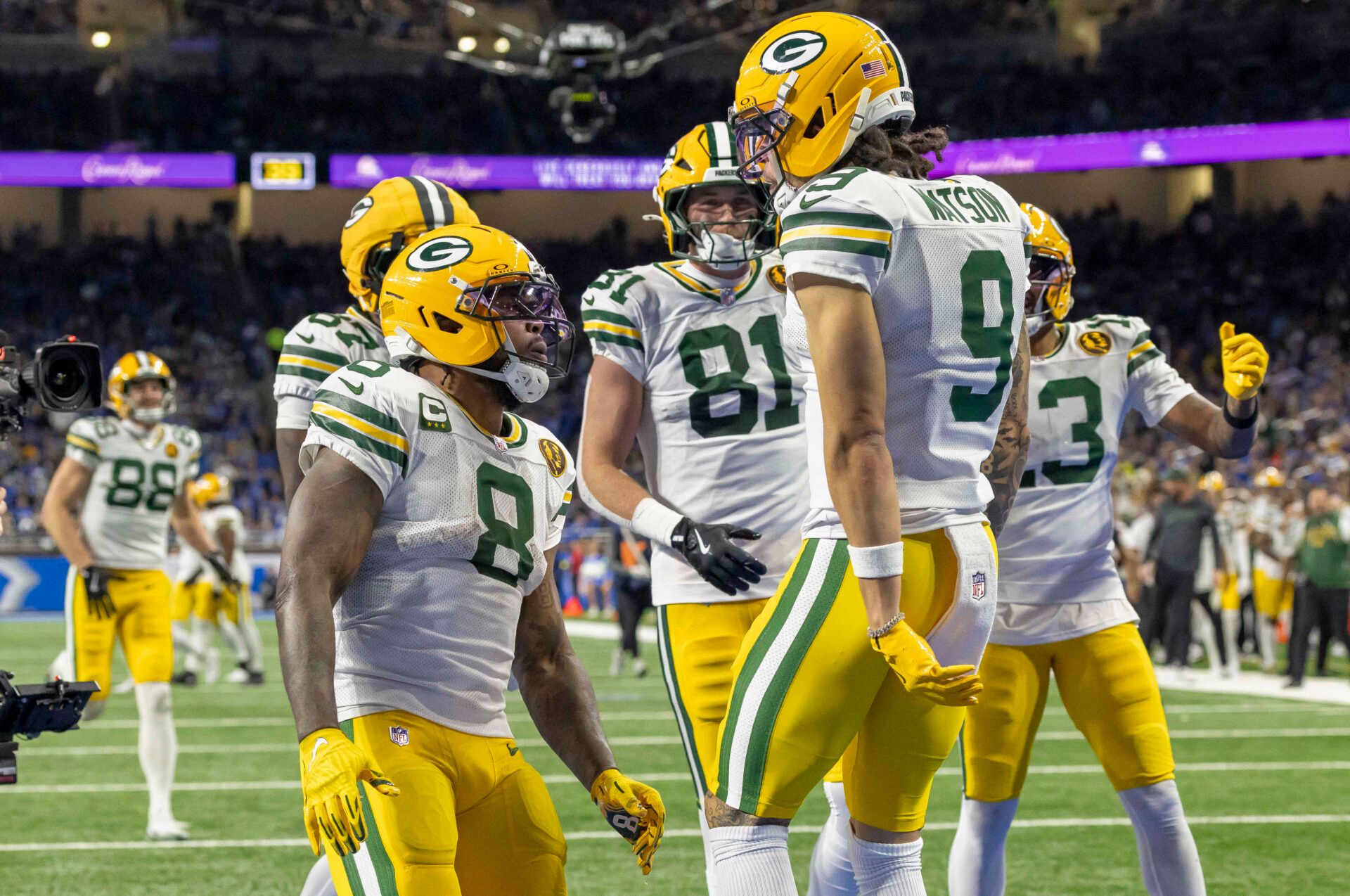 Green Bay Packers running back Josh Jacobs (8) and Green Bay Packers wide receiver Christian Watson (9) celebrate after a touchdown against the Detroit Lions during the third quarter at Ford Field.