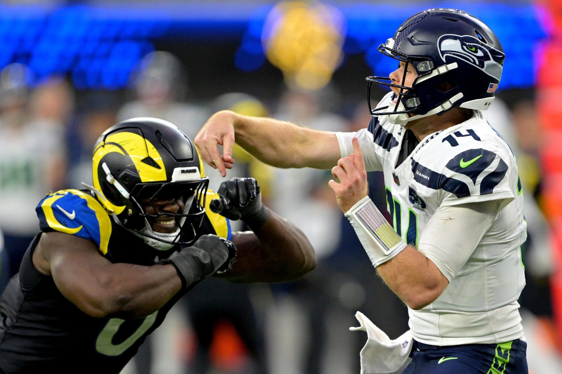 Seattle Seahawks quarterback Sam Darnold (14) is pressured by Los Angeles Rams linebacker Byron Young (0) at SoFi Stadium.