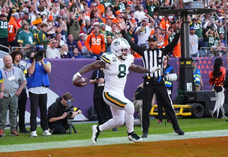 Green Bay Packers running back Josh Jacobs (8) reacts after a touchdown during the second quarter against the Denver Broncos at Empower Field at Mile High.