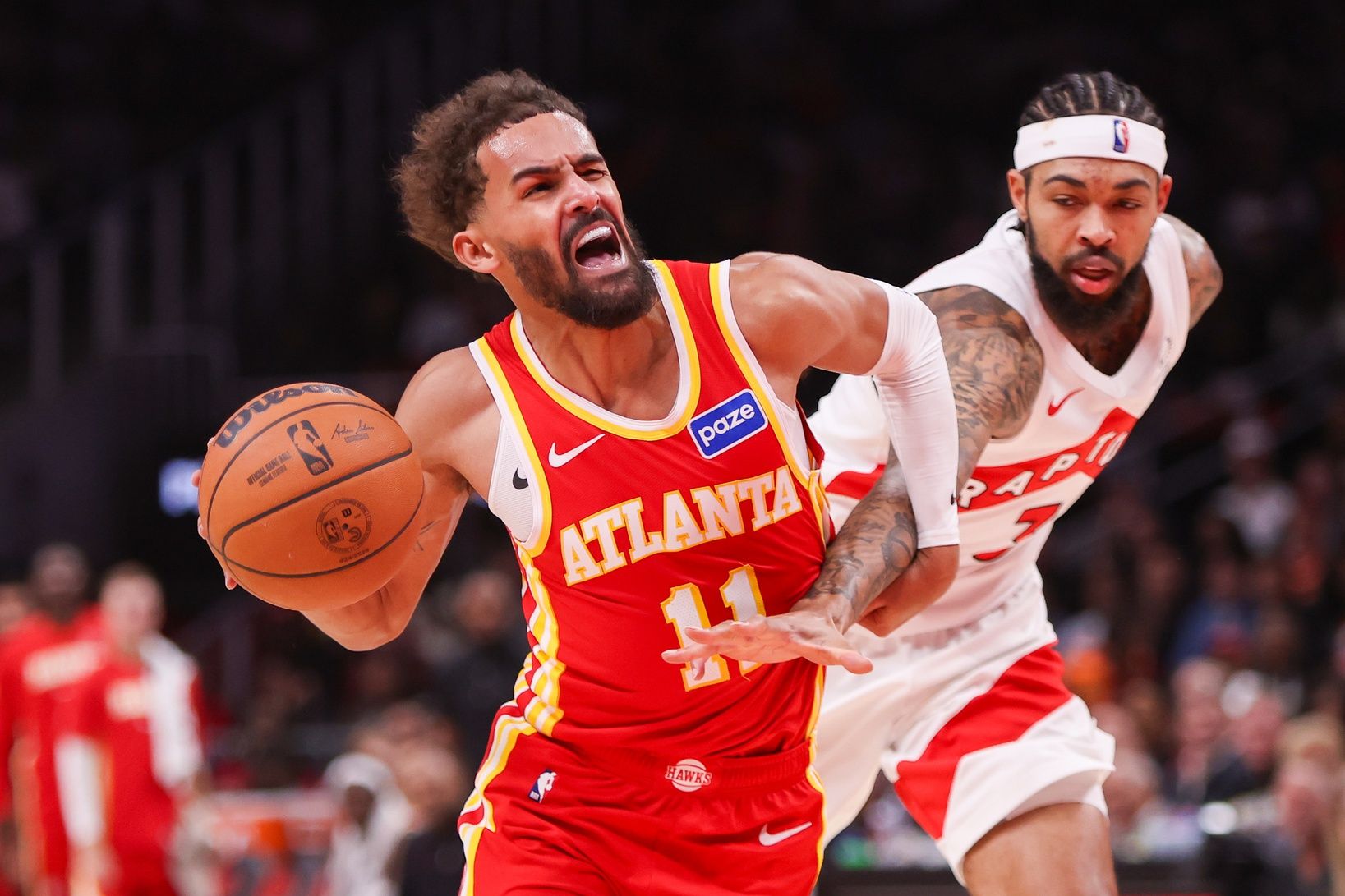 Atlanta Hawks guard Trae Young (11) is fouled by Toronto Raptors forward Brandon Ingram (3) in the second quarter at State Farm Arena.