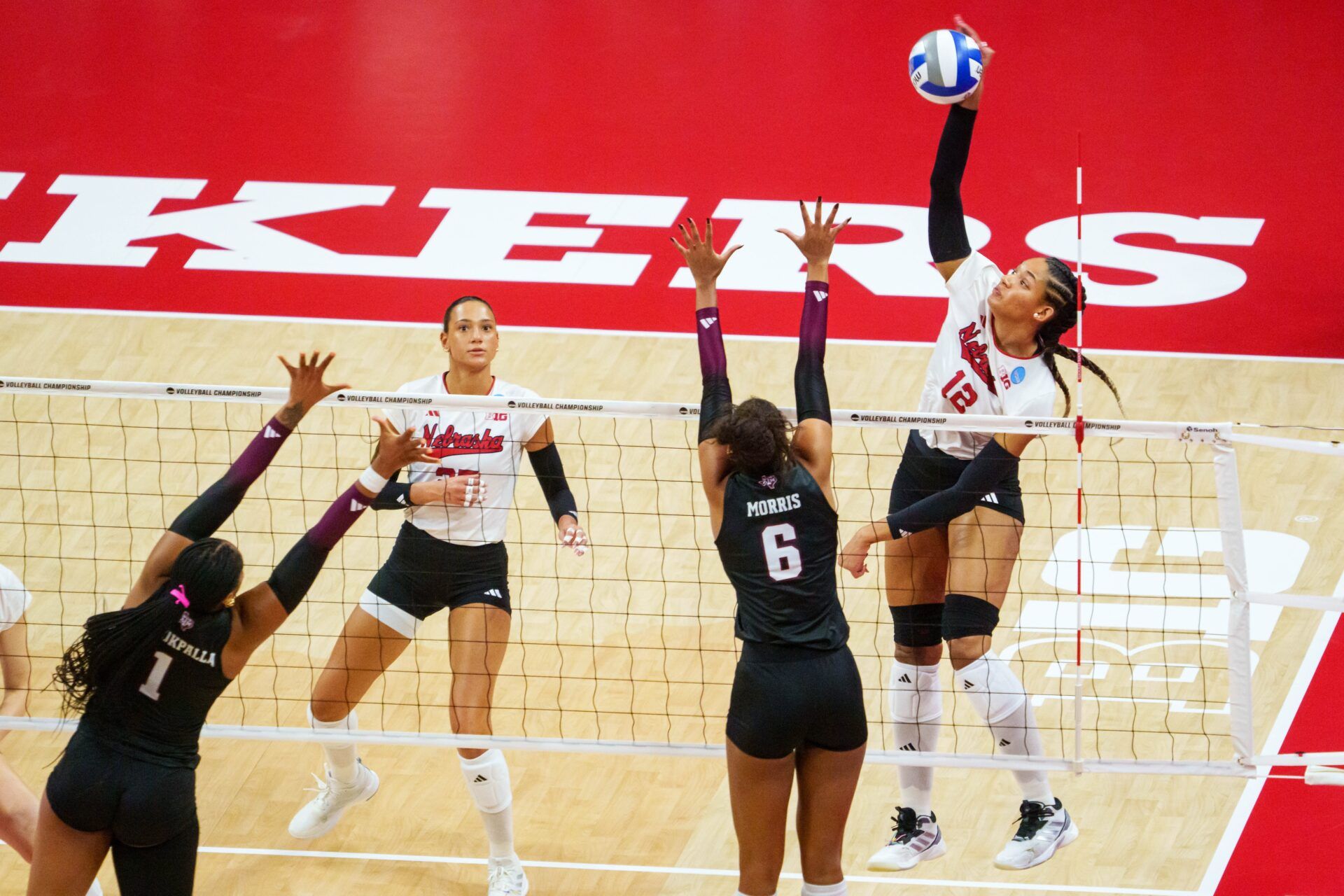 Nebraska Cornhuskers outside hitter Taylor Landfair (12) attacks against Texas A&M Aggies opposite Taryn Morris (6) and middle blocker Ifenna Cos-Okpalla (1) during the first set at Bob Devaney Sports Center.