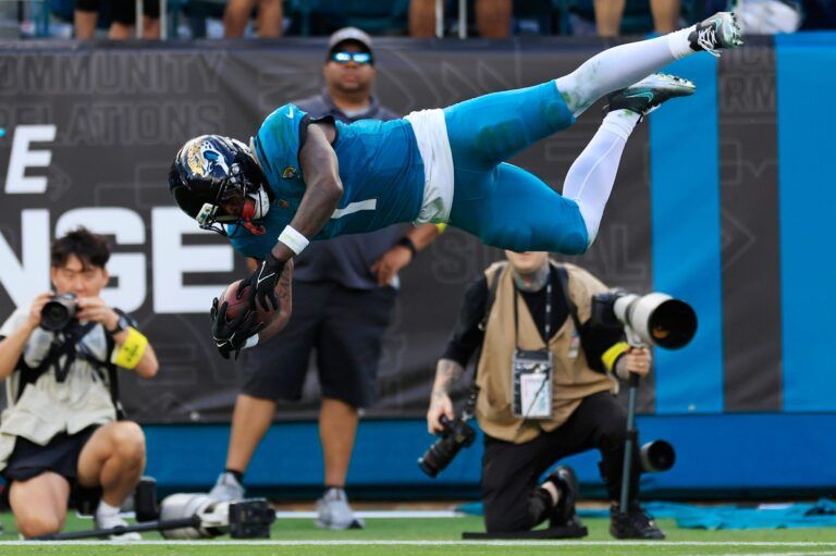Jacksonville Jaguars running back Travis Etienne Jr. (1) leaps to score a rushing touchdown during the fourth quarter of an NFL football matchup at EverBank Stadium, Sunday, Dec. 14, 2025, in Jacksonville, Fla. The Jaguars defeated the Jets 48-20. [Corey Perrine/Florida Times-Union]