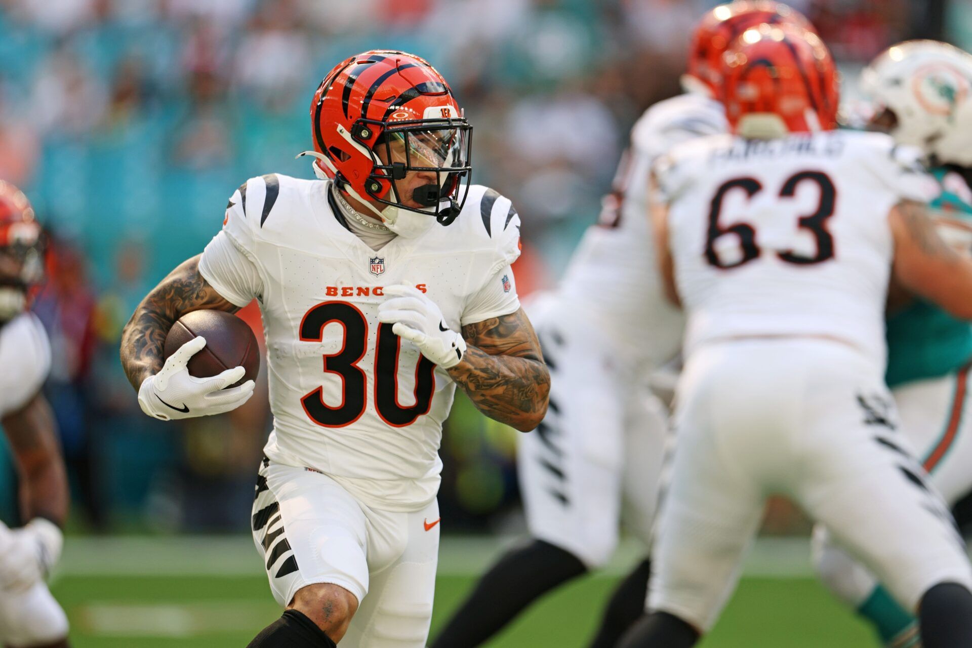 Cincinnati Bengals quarterback Joe Burrow (9) hands off the ball to Cincinnati Bengals running back Chase Brown (30) during the first quarter at Hard Rock Stadium.