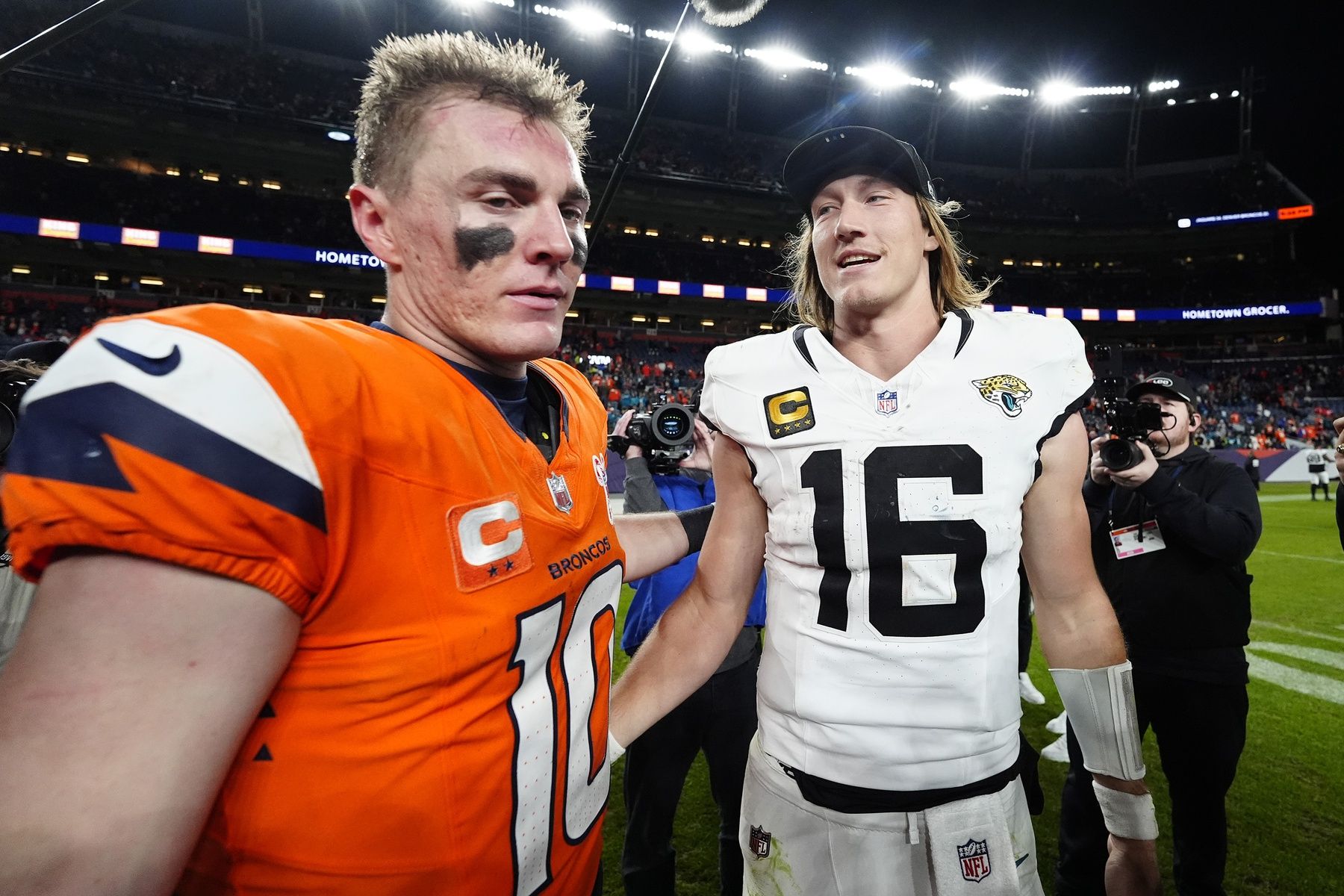 Denver Broncos quarterback Bo Nix (10) and Jacksonville Jaguars quarterback Trevor Lawrence (16) meet after the game at Empower Field at Mile High.