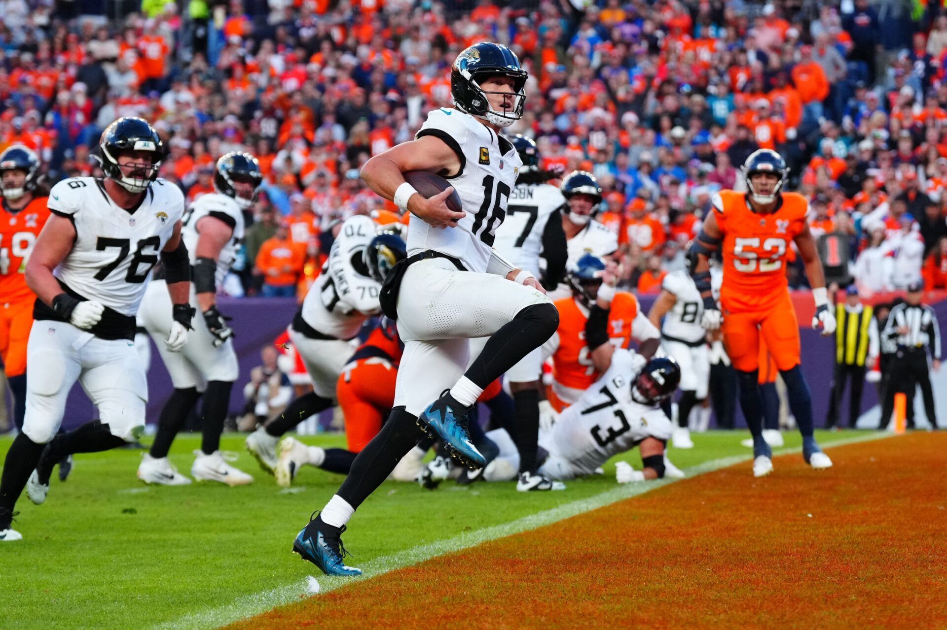 Jacksonville Jaguars quarterback Trevor Lawrence (16) rushes for a touchdown against the Denver Broncos during the second half at Empower Field at Mile High.