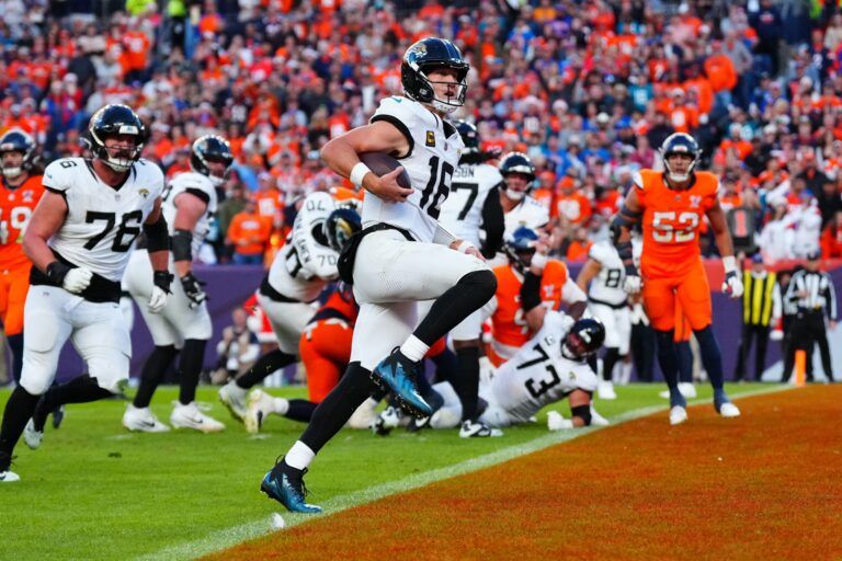 Jacksonville Jaguars quarterback Trevor Lawrence (16) rushes for a touchdown against the Denver Broncos during the second half at Empower Field at Mile High.