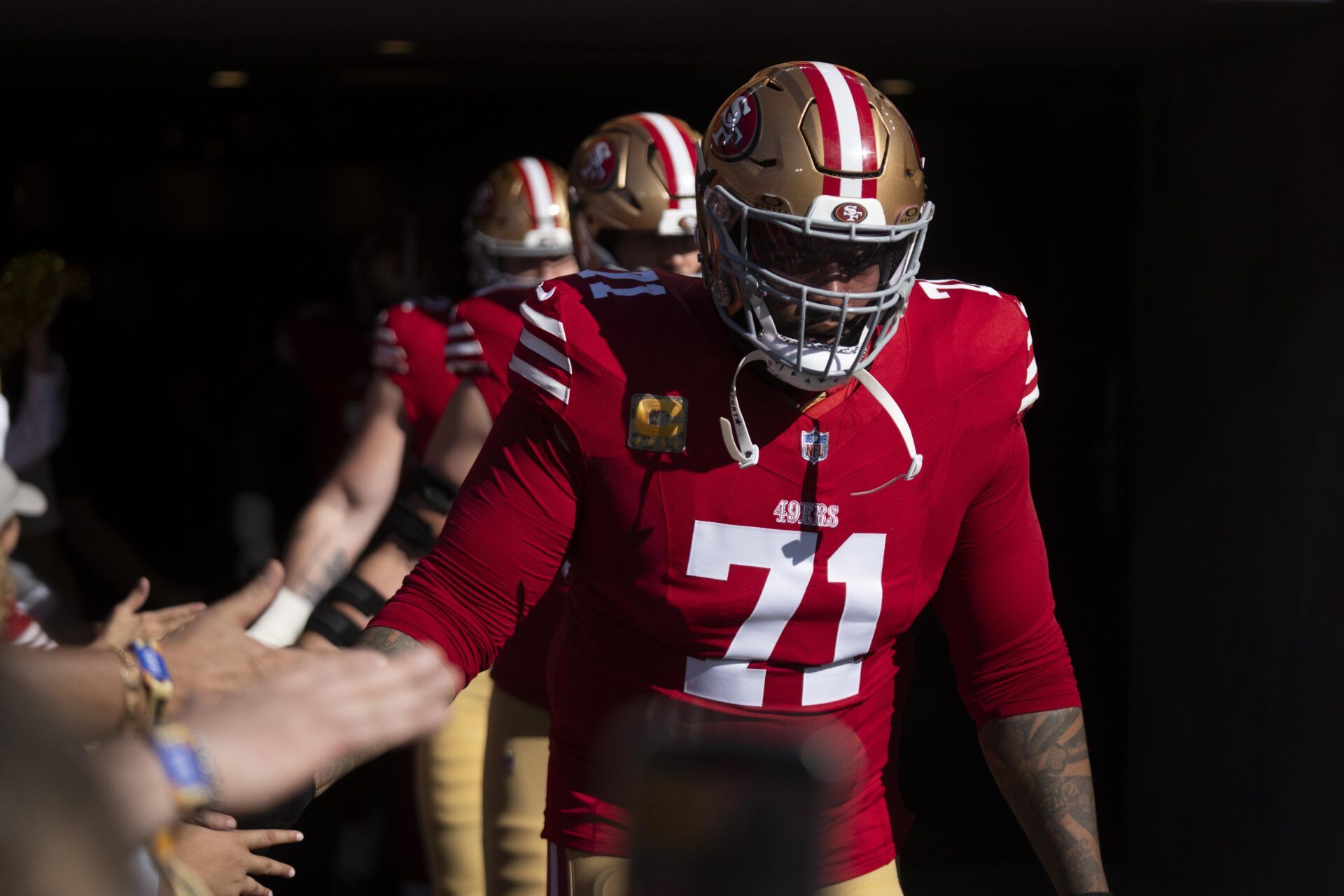 San Francisco 49ers offensive tackle Trent Williams (71) high-fives fans as he runs onto the field prior to the game against the Los Angeles Rams at Levi's Stadium.
